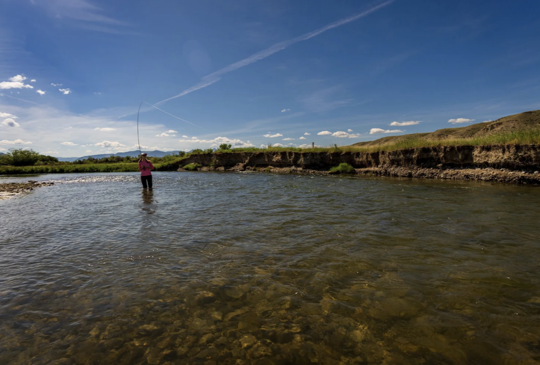 Fly angler casting on the Ruby River under wide blue skies in southwest Montana