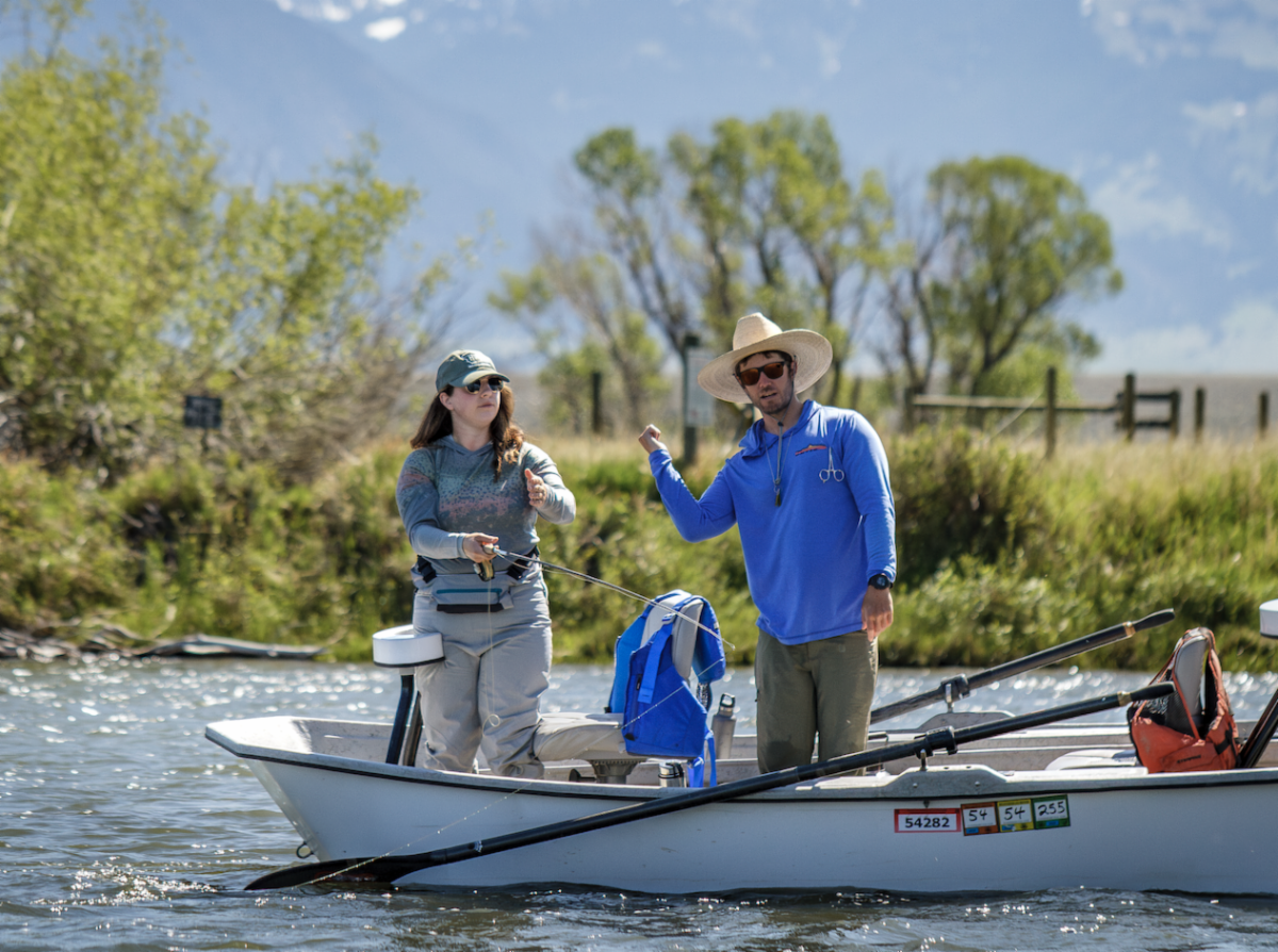 Fly fishing guide instructing an angler from a drift boat during a Montana fishing academy session