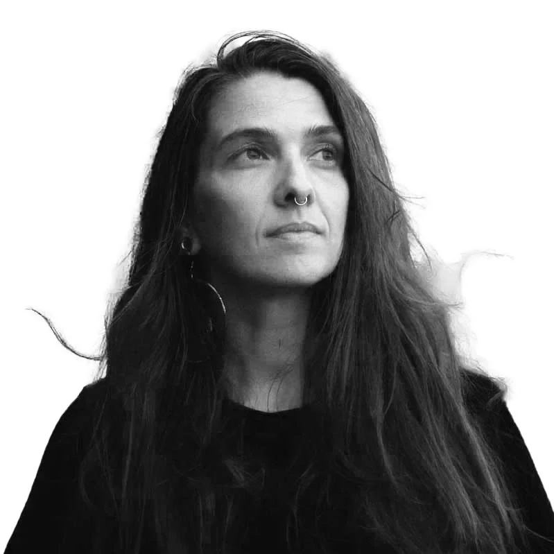 Black and white portrait of woman with nose ring and long hair, looking upwards.