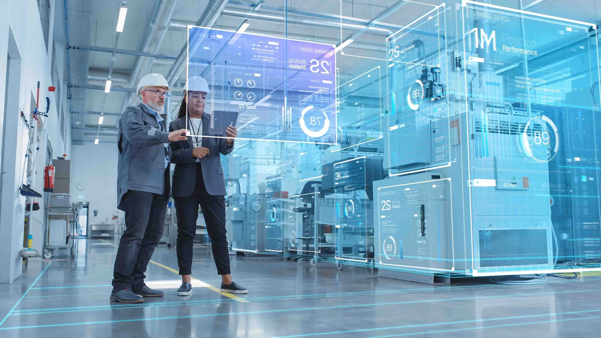 Two engineers in hard hats and business attire examining digital holographic data in a high-tech industrial facility.