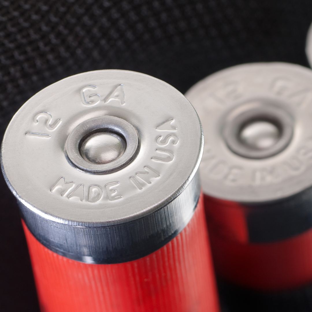 Close-up of two red batteries, with the top of one battery showing the embossed text '12 GA' and 'Made in USA'.