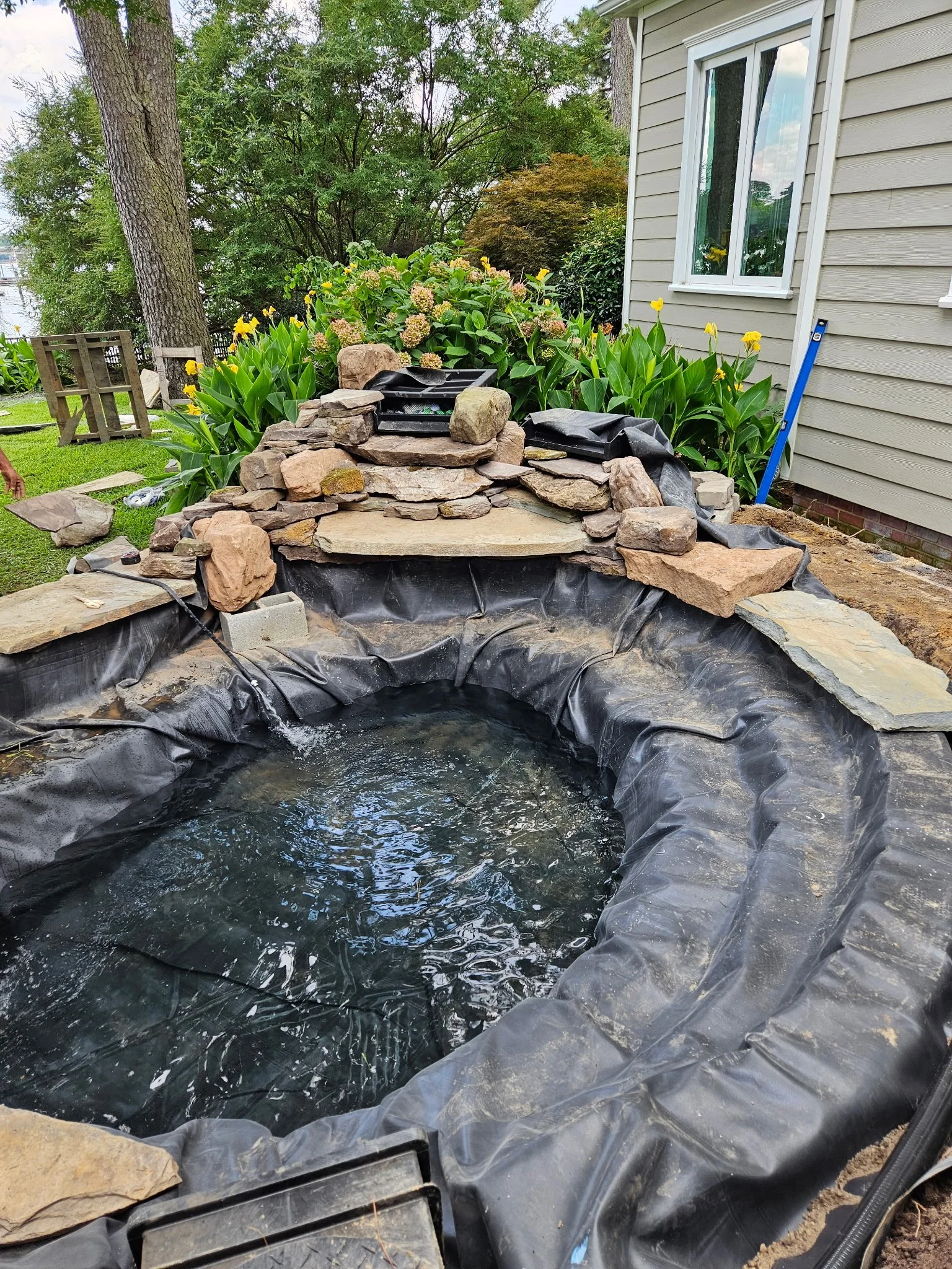 Process — Pond building with natural stone: excavation, liner + underlayment, rock edge, and tuned circulation.