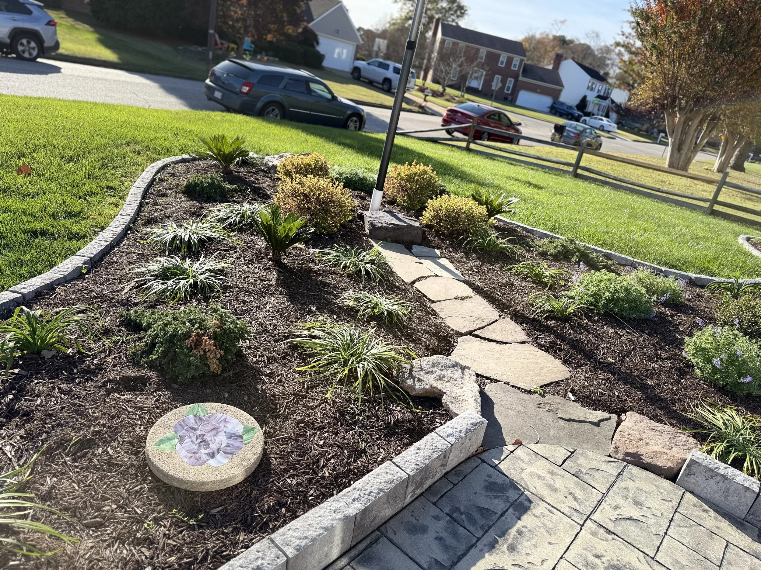 After — Stone edging installation, soil prep, plant installation, and a clean mulch finish.