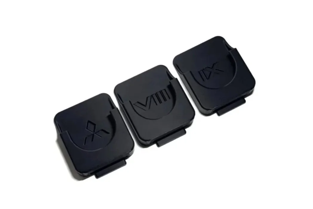 Three black compact devices with buttons labeled with icons, arranged in a row.