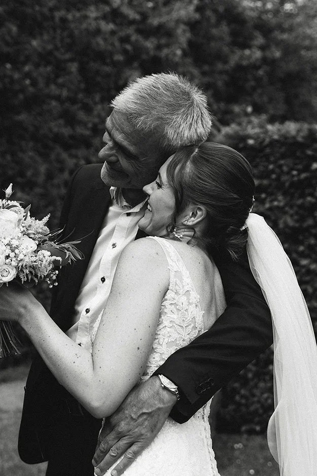 bride and father in a hug after ceremony