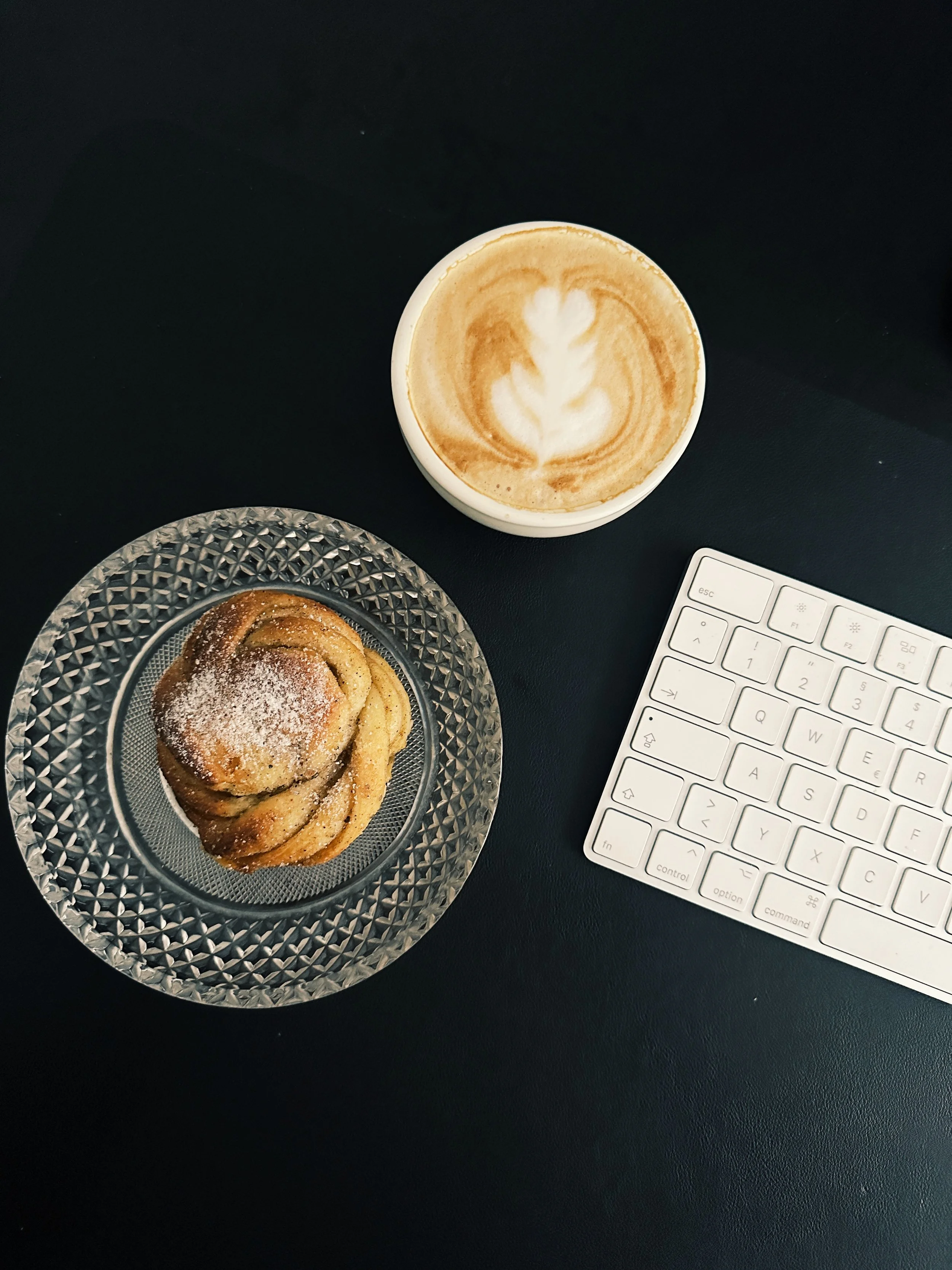 working situation with coffee and cinnamon bun