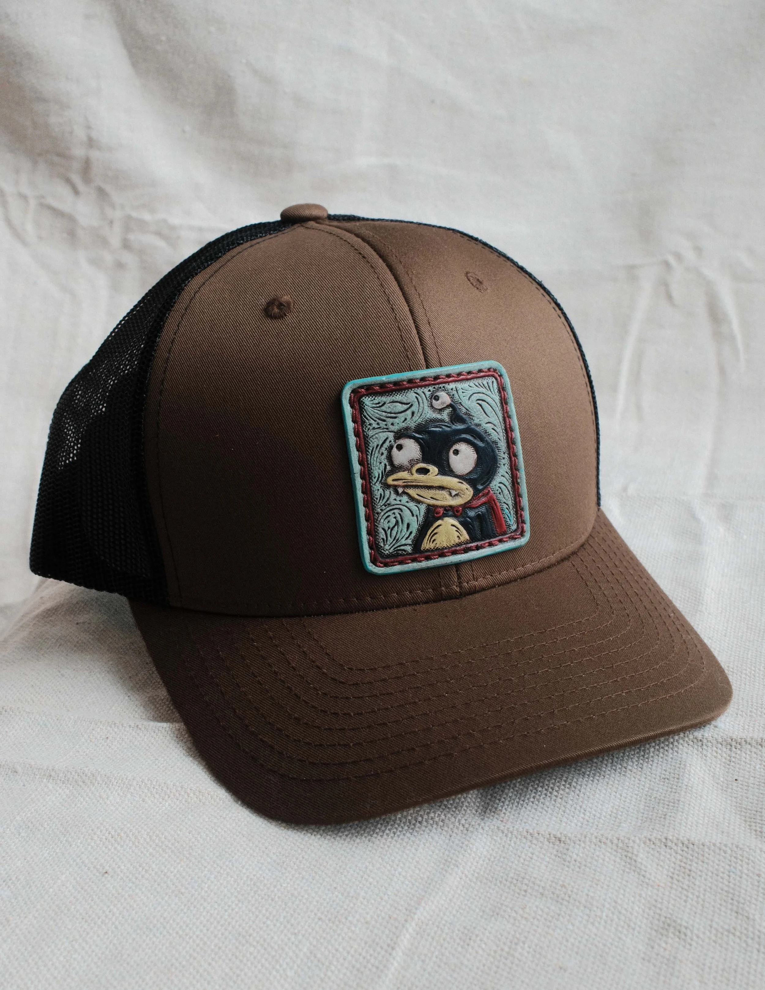 Non Descript Lil Guy Leather Patch Trucker Hat