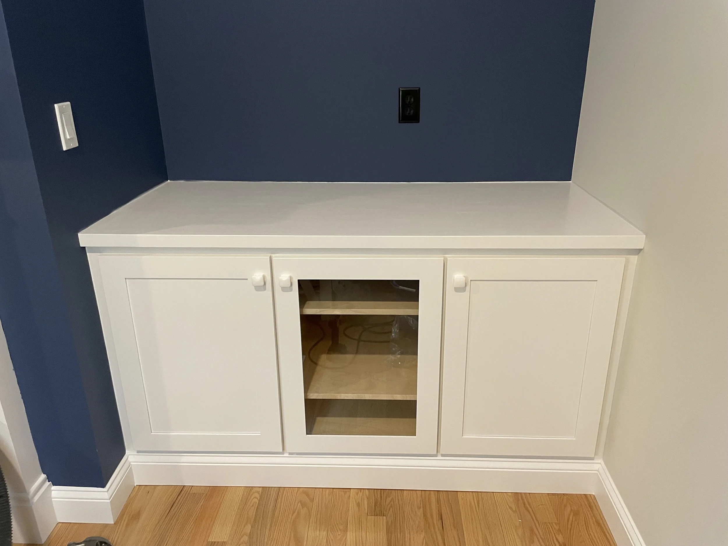 Fireplace side by side built-in cabinets with adjustable shelves and clear center display cabinet