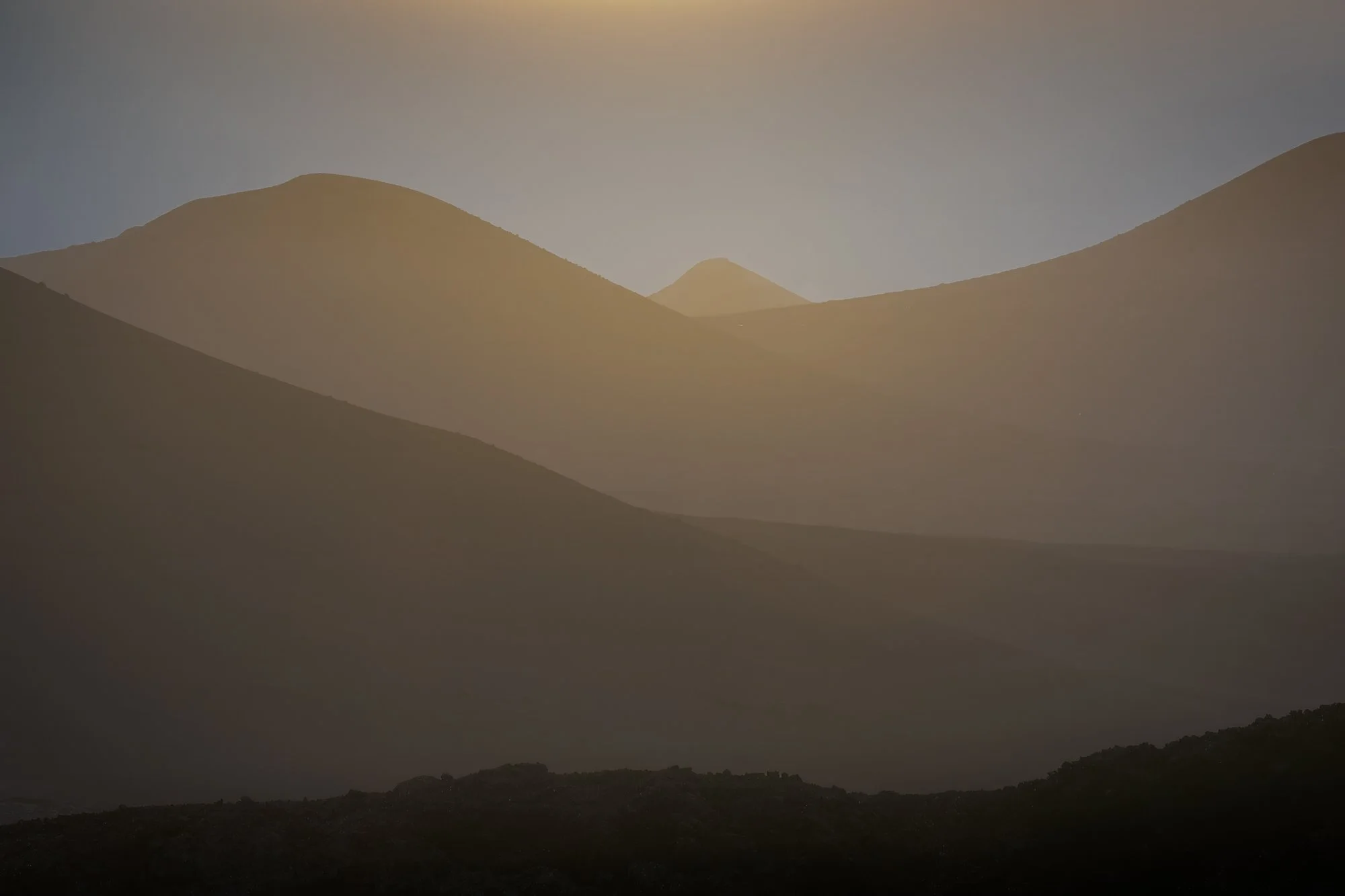 sunset view of layers of volcanoes in Lanzarote