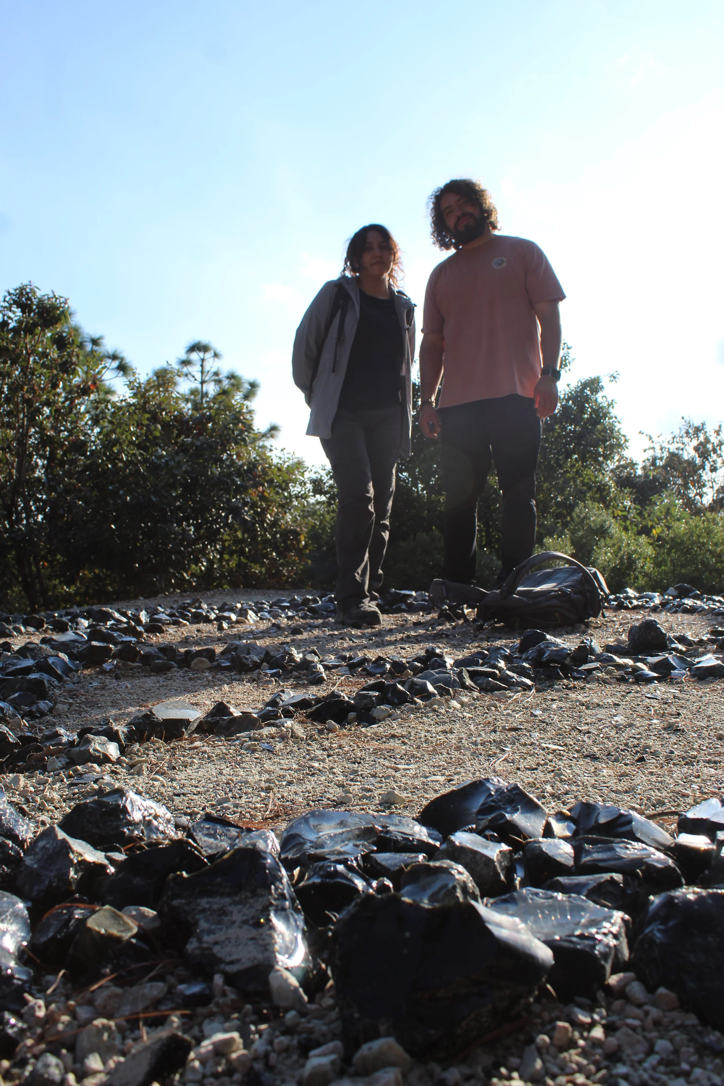 personas posando para foto en senderos cubiertos de obsidiana