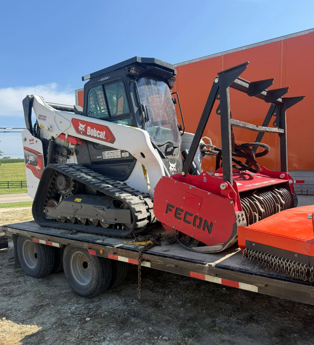 3D Excavating skid steer equipped with forestry mulching attachment for land clearing and brush removal