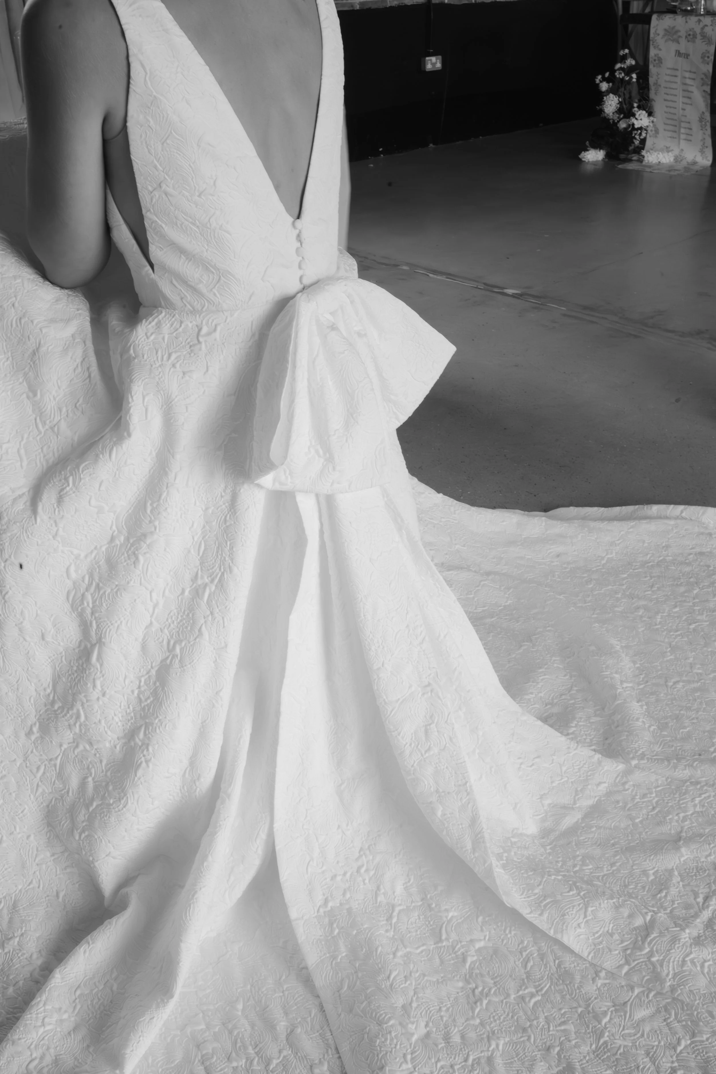 Elegant wedding photography Suffolk and Norfolk β close-up of bride in textured white gown near floral table setting