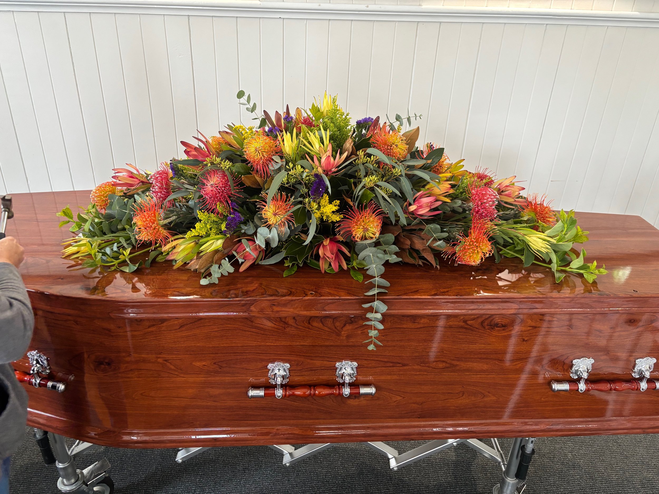 A traditional timber coffin never goes out of style, and this particular native 'spray' (floral coffin topper) was breath taking.