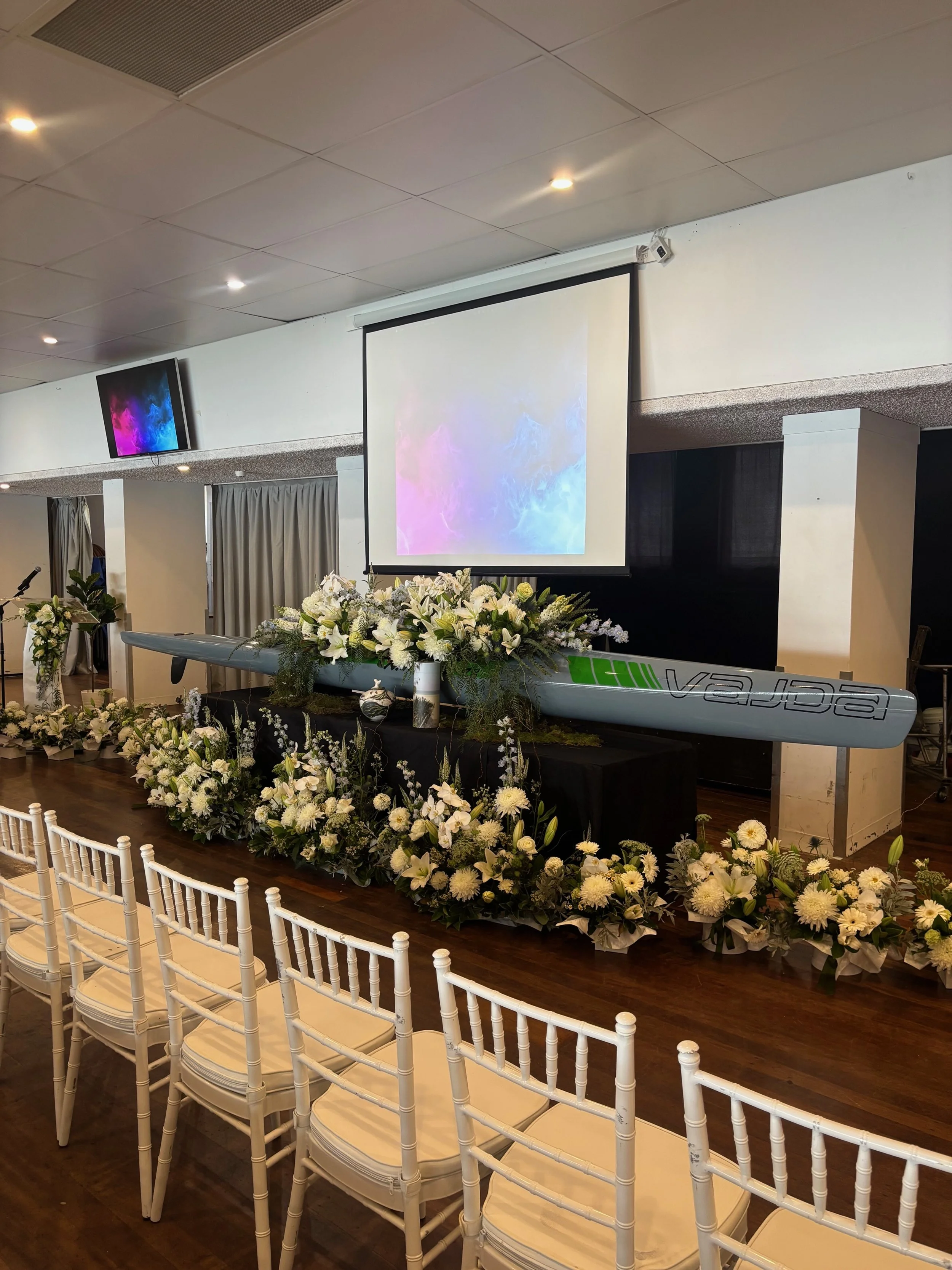 Let's make it personal. An alter made out of a kayak and filled with flowers is a starting point for a man who loved the water. 