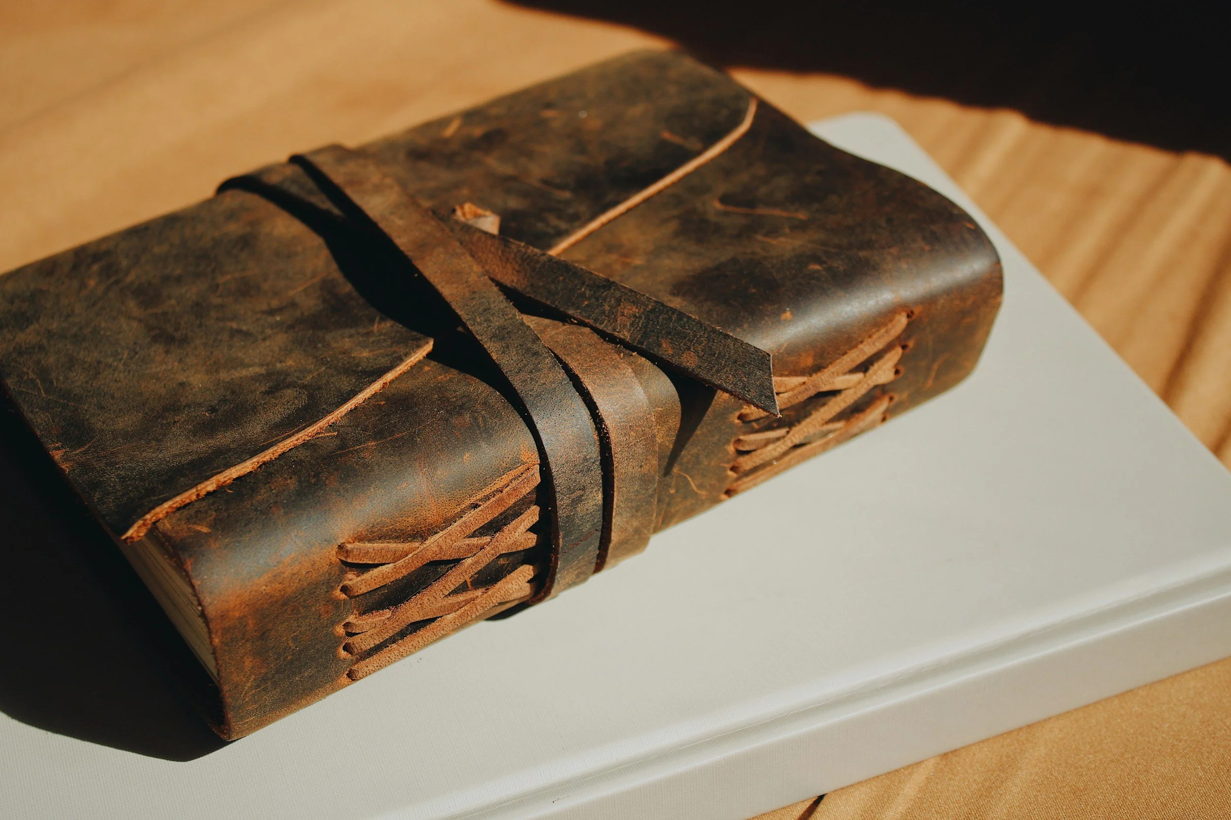 A worn, closed journal representing the unspoken burdens that pastors and missionaries carry alone, without a safe place to process what they have experienced