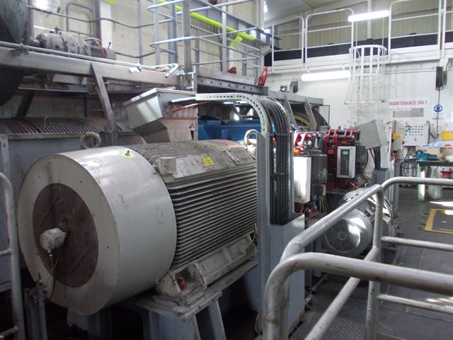 Industrial machinery in a maintenance area with metal pipes and equipment.