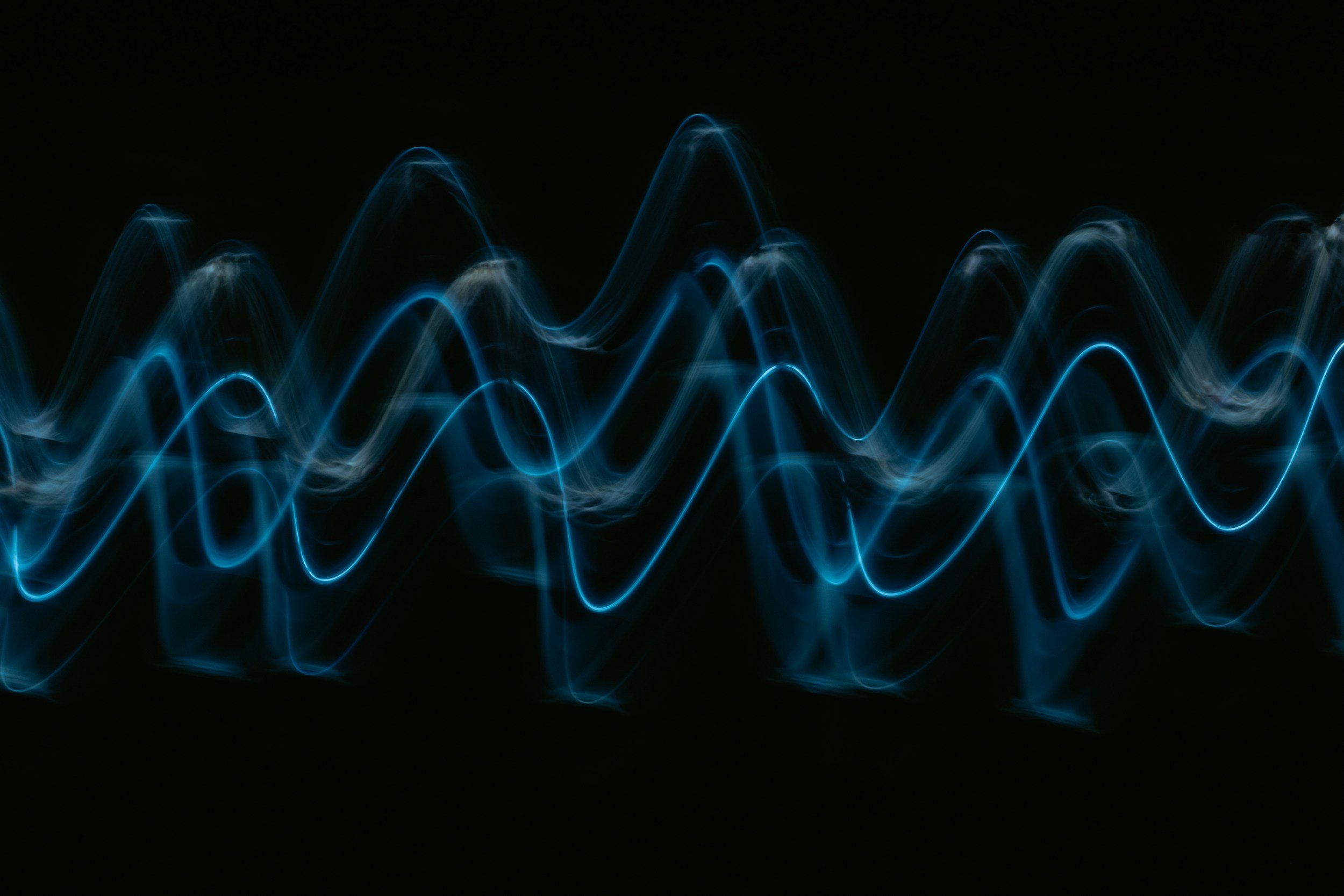 Blue neon light waves on a black background.
