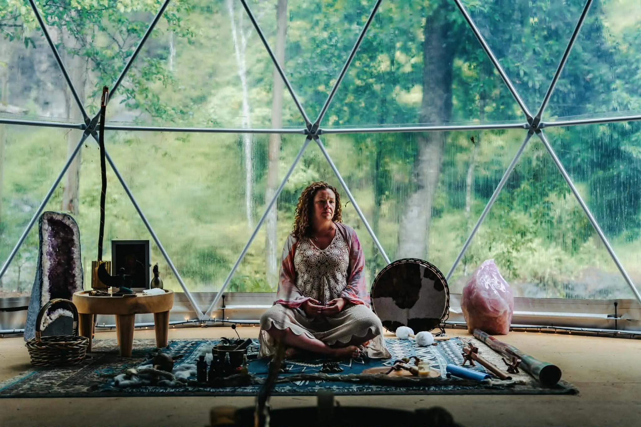 Hayley Simpson hosting a sound and 9D breathwork event at a retreat surrounded by crystals, sound instruments and nature.