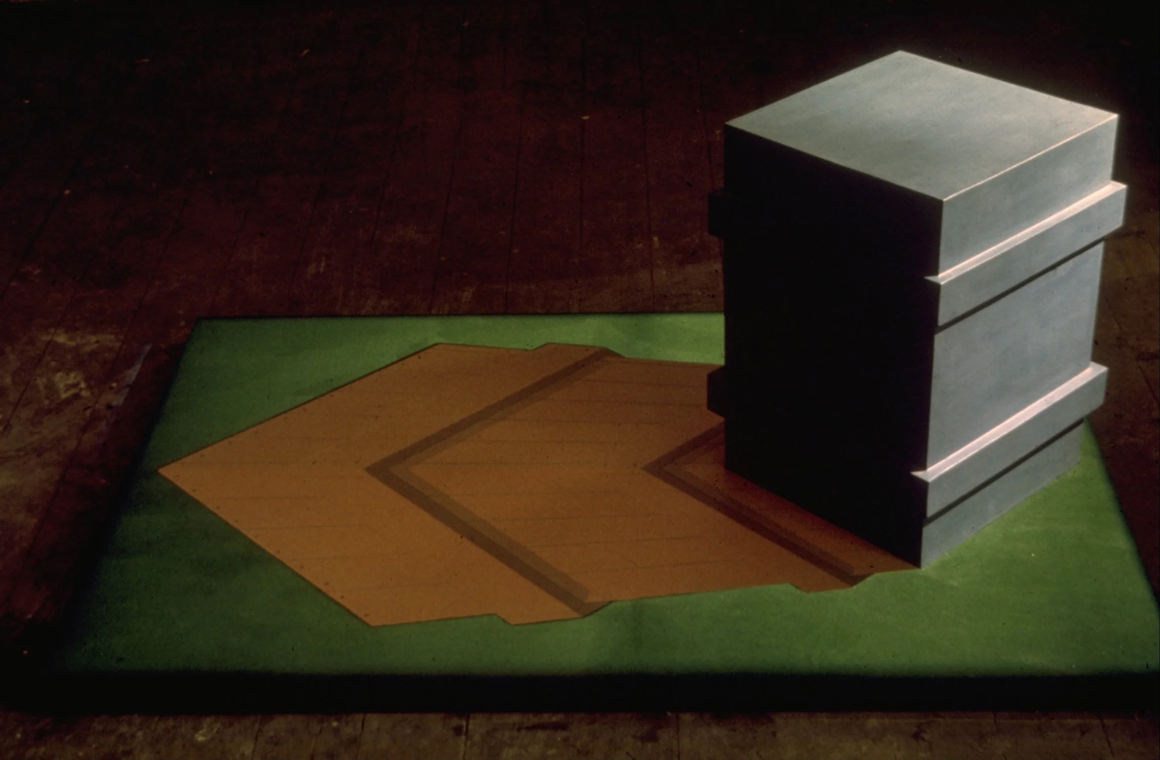 Shadow Crate I. Wood and paint on green baize with framing spotlight. 72' long x 38' high.