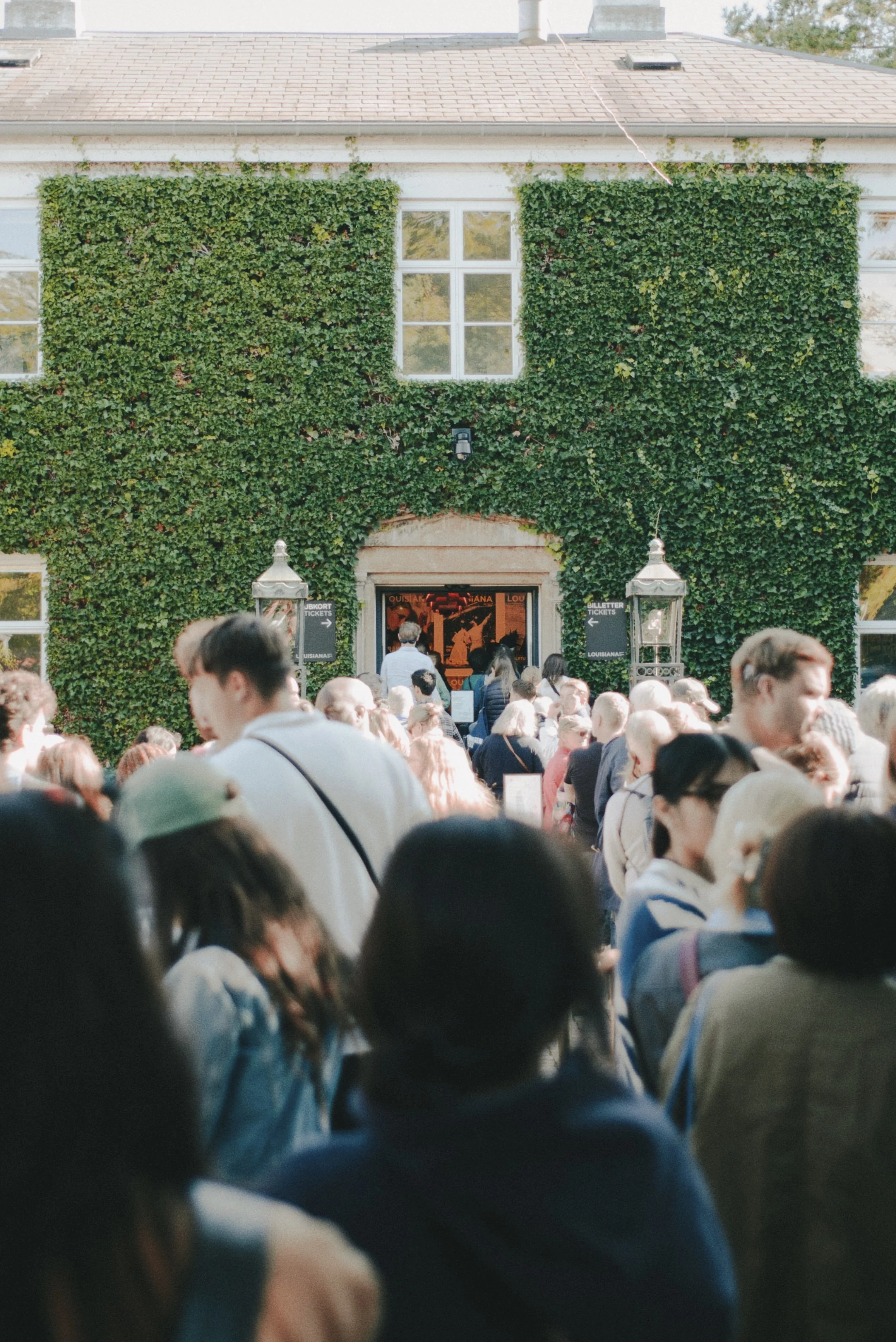 Crowd outside ivy-covered building entrance