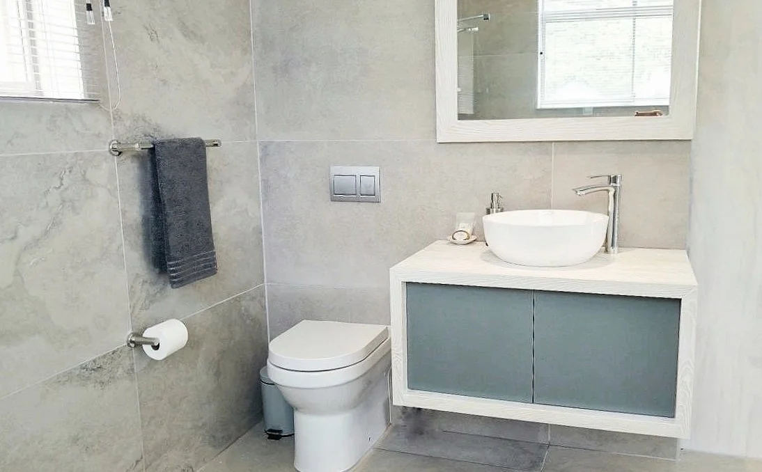 Modern bathroom with toilet, vanity, and mirror