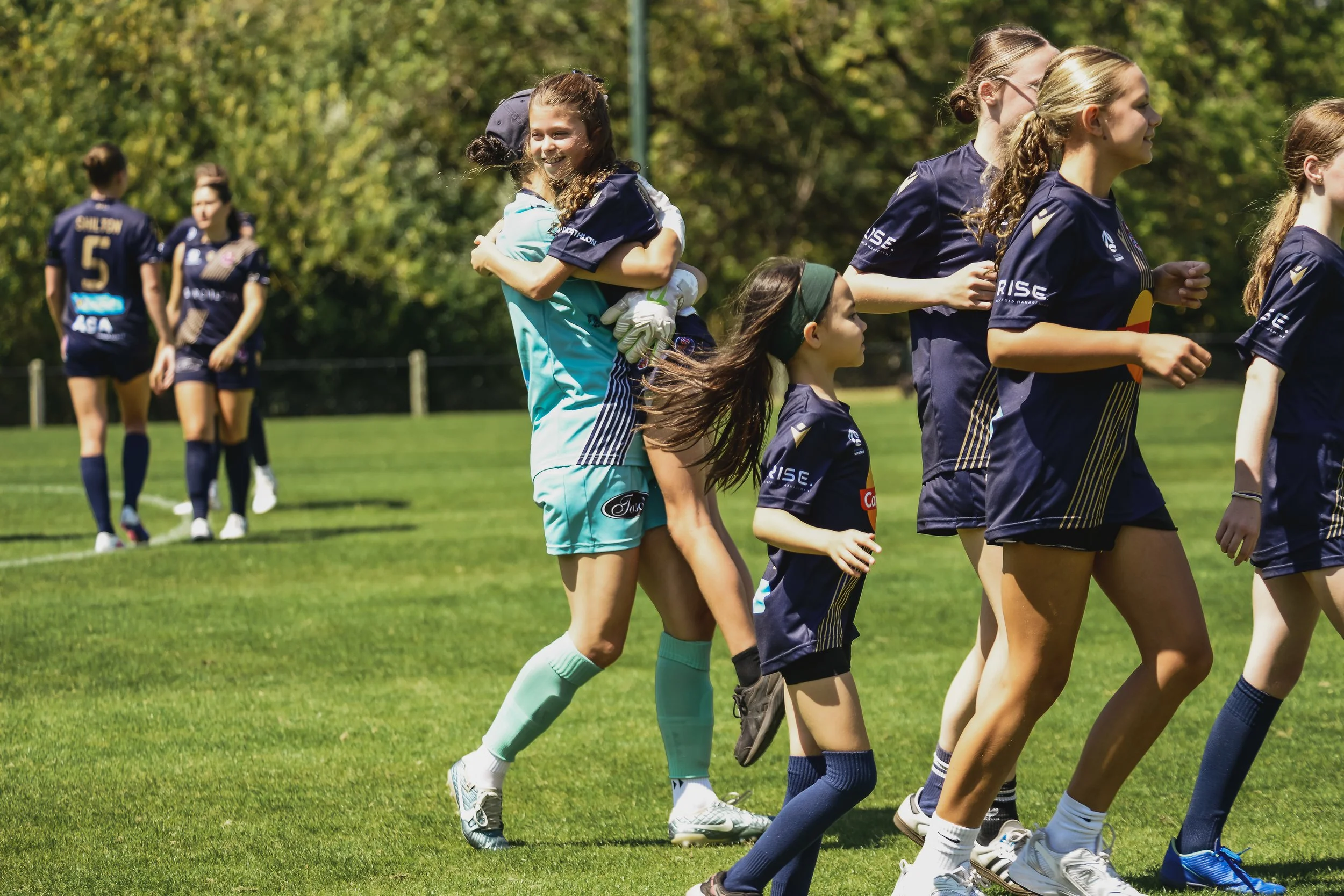 Junior girls celebrating a Senior team win after community football match in Melbourne