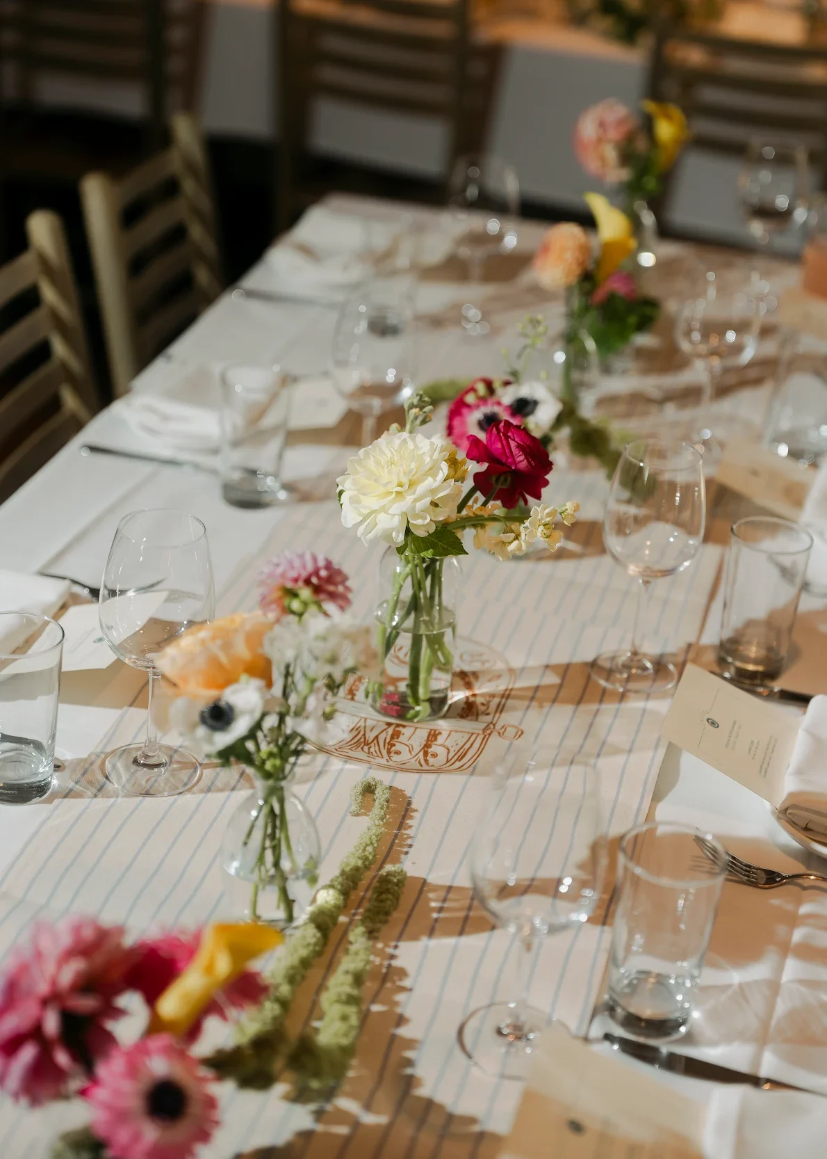 Elegant, low-profile bud vase centerpieces by Quogue Flower Shop, perfect for high-end rehearsal dinners, intimate bridal showers, and luxury private home entertaining across the Hamptons.