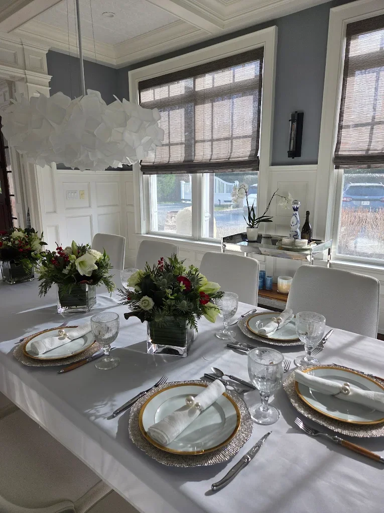 Sophisticated winter estate table designs featuring classic holiday greens and pristine white florals, custom-tailored by Quogue Flower Shop for high-end seasonal events and Hamptons wedding receptions.