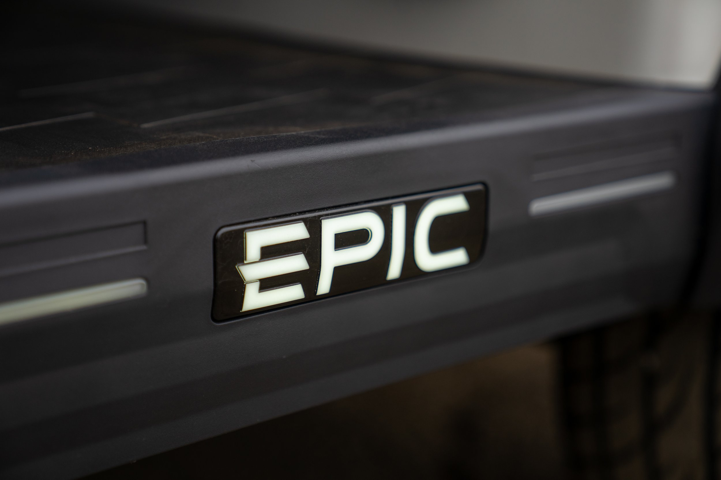 Close-up of a black emergency stop button labeled 'EPIC' in illuminated lettering.