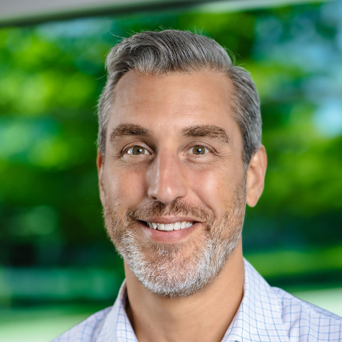 Smiling man with grey hair in a white button down shirt