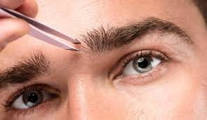 Person plucking eyebrows with tweezers