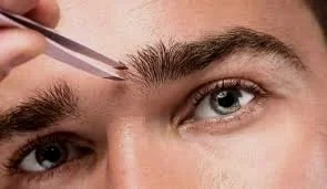 Person applying eyebrow makeup with tweezers.