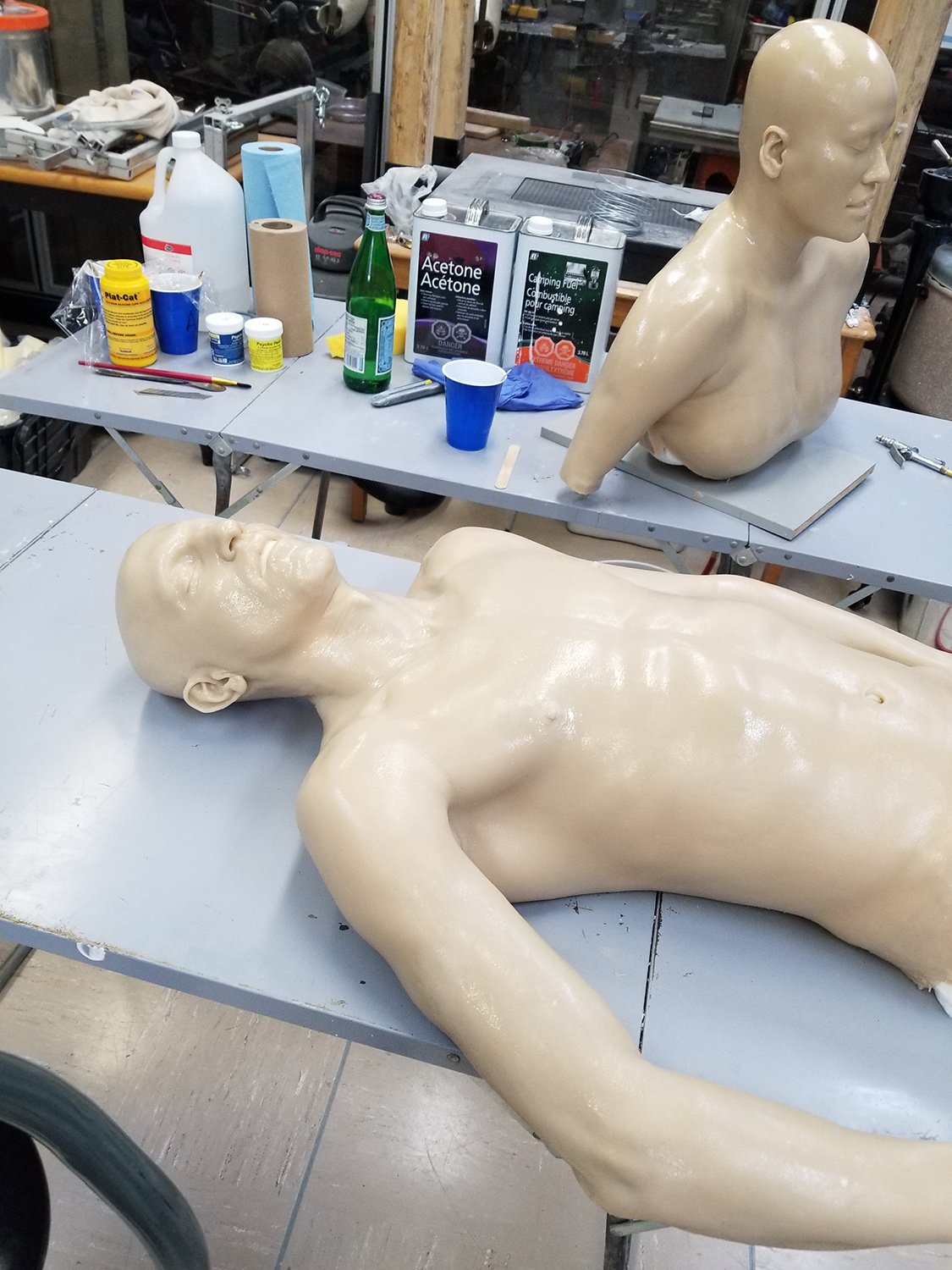 Atelier avec matériel artistique et sculptures partiellement finies.
