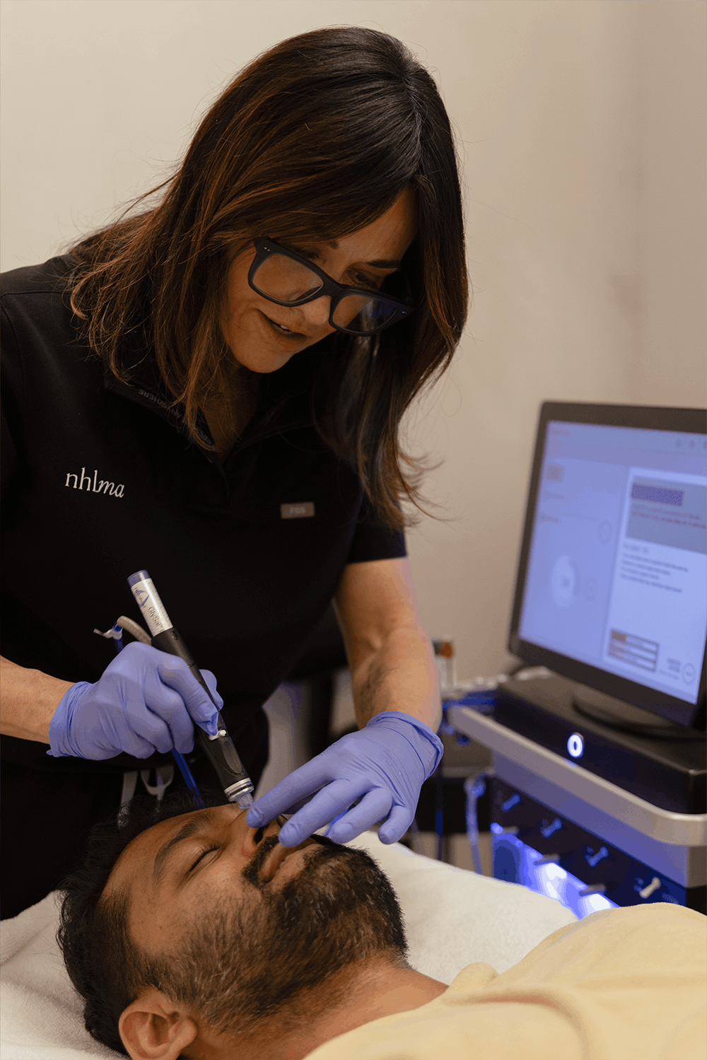 a woman giving a man a hydrafacial in scottsdale at nhlma