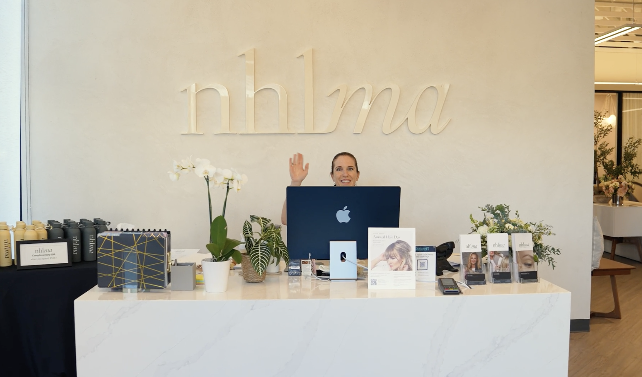 the front desk staff waving hello at nhlma hair loss experts scottsdale