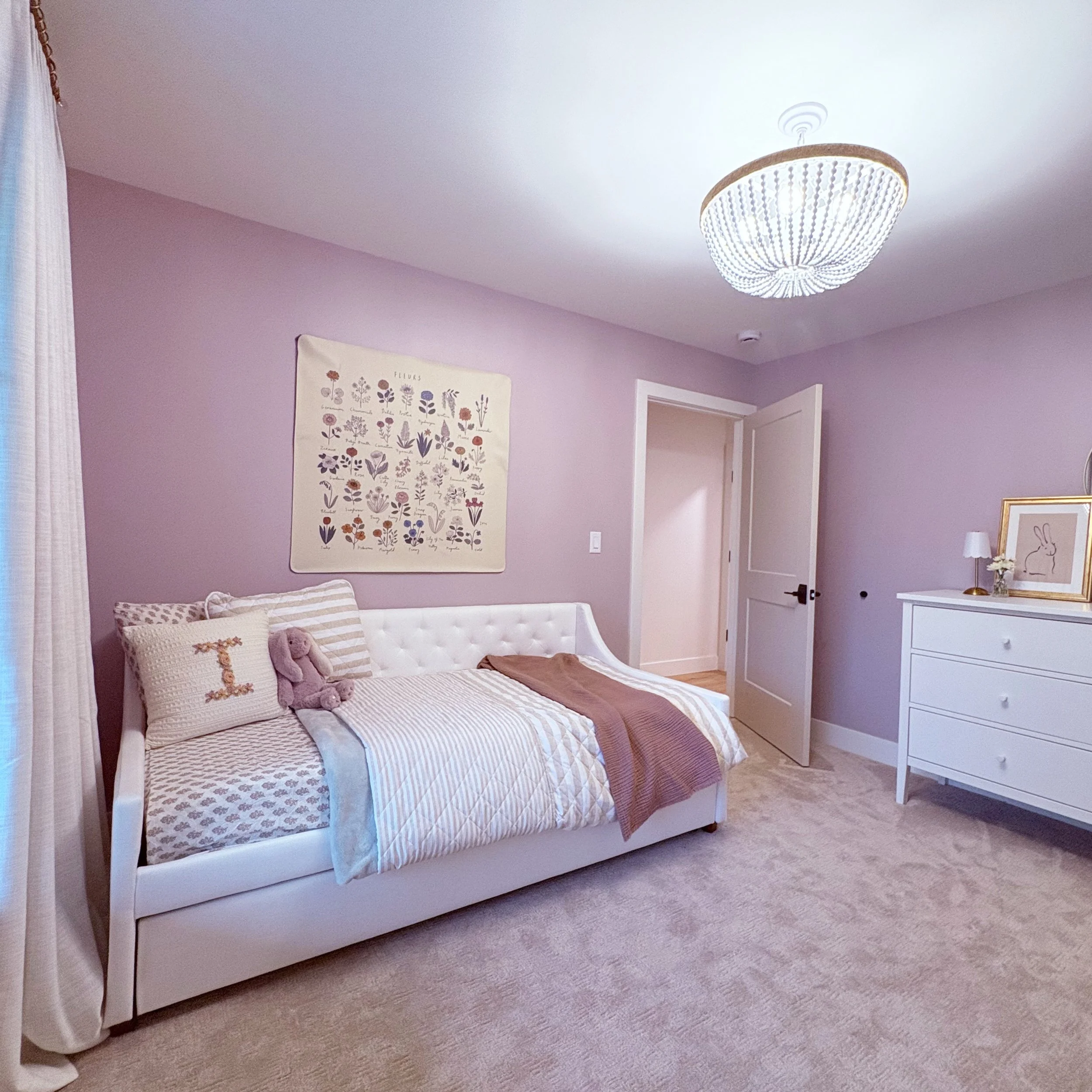 This sweet little girl's room all started with the request for mauve walls. Sherwin Williams Studio Mauve set the perfect backdrop to layer patterns of stripes, florals, and tonal solids. Touches of whimsy were added with flowers and bunny rabbits! B