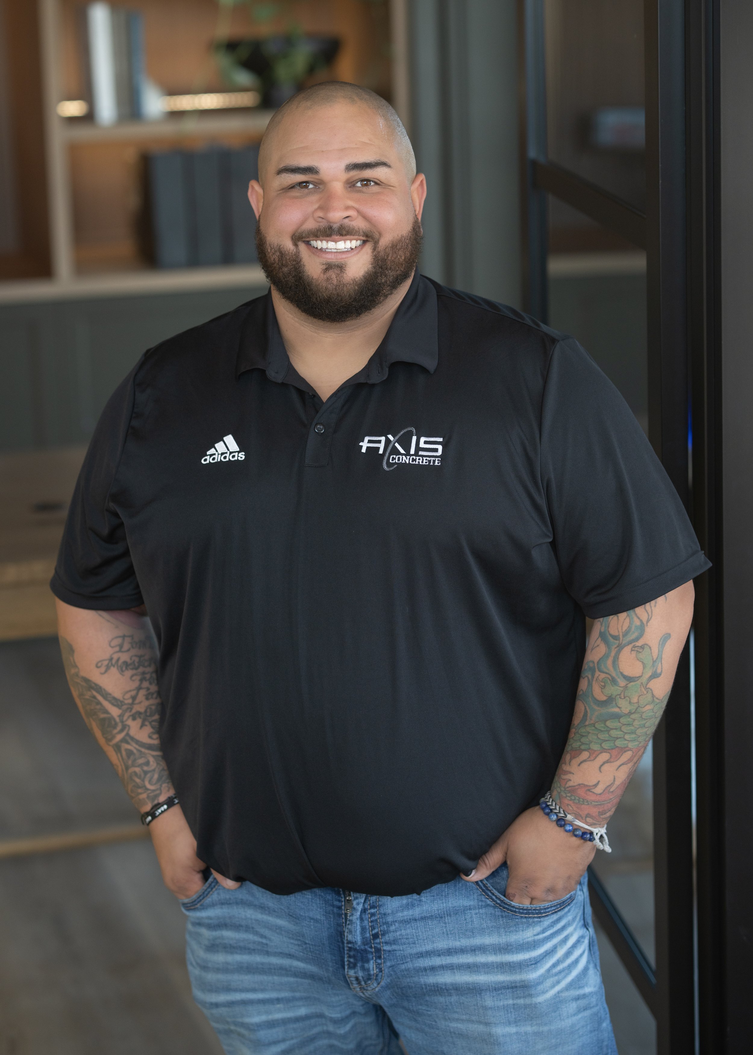Man smiling in a black polo shirt with "Paramount Builders" logo on it.