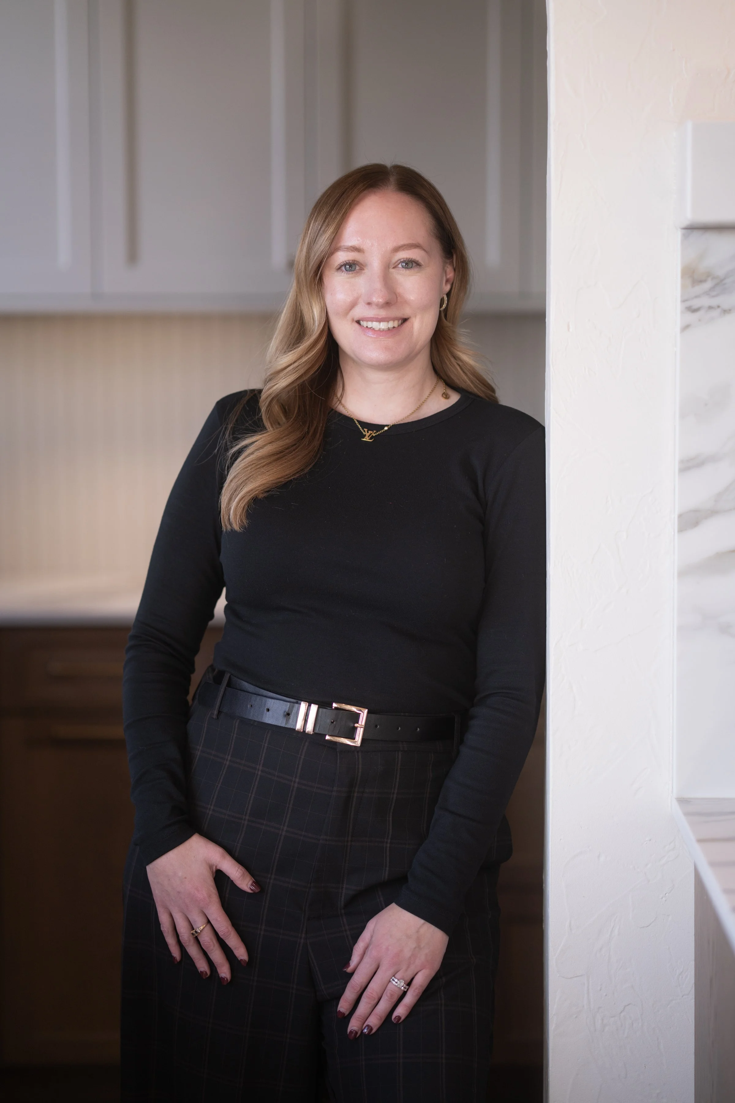 Smiling woman with long blonde hair wearing a gray sweater