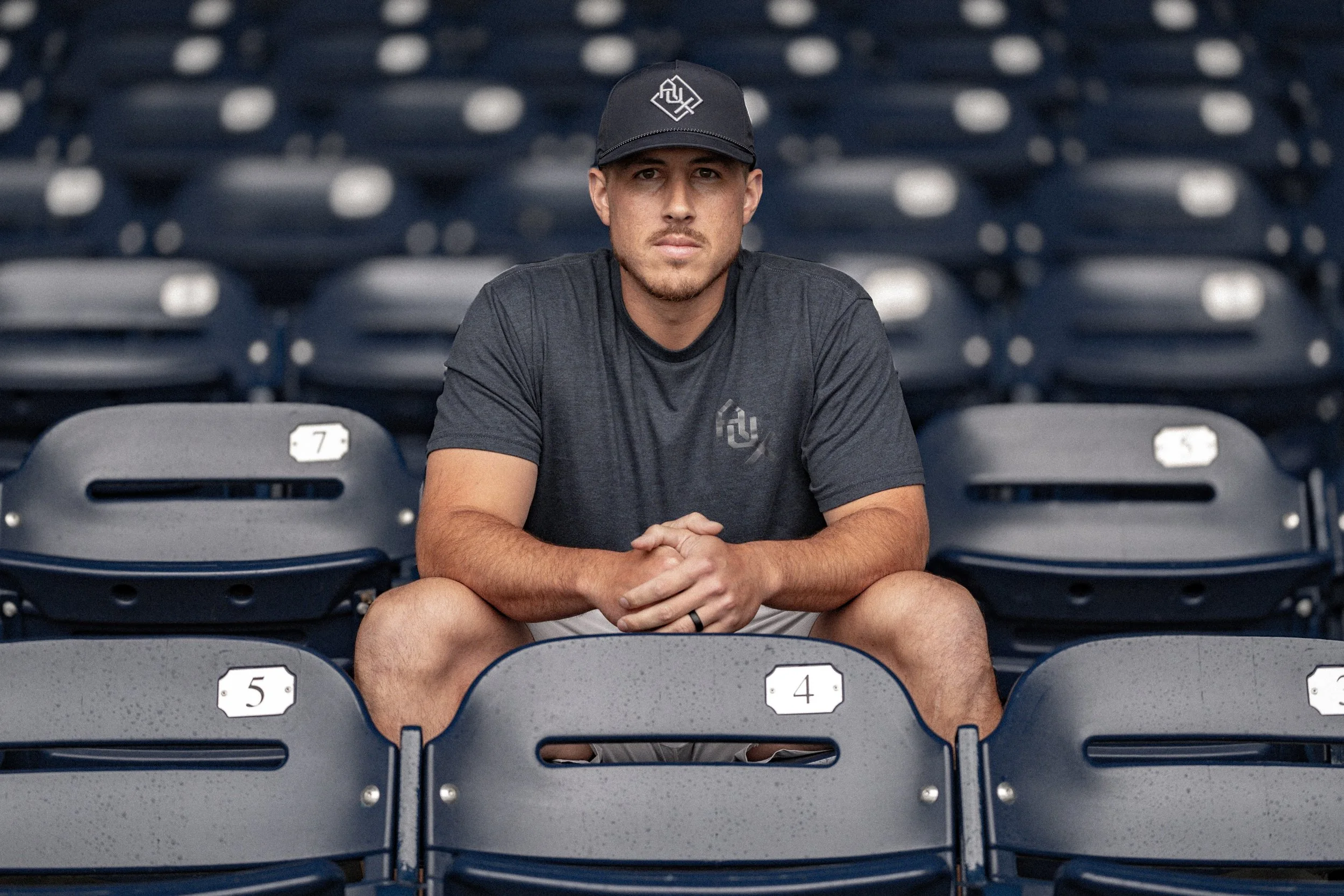 Professional baseball coach sitting in the stands, college baseball training, trackman analytics