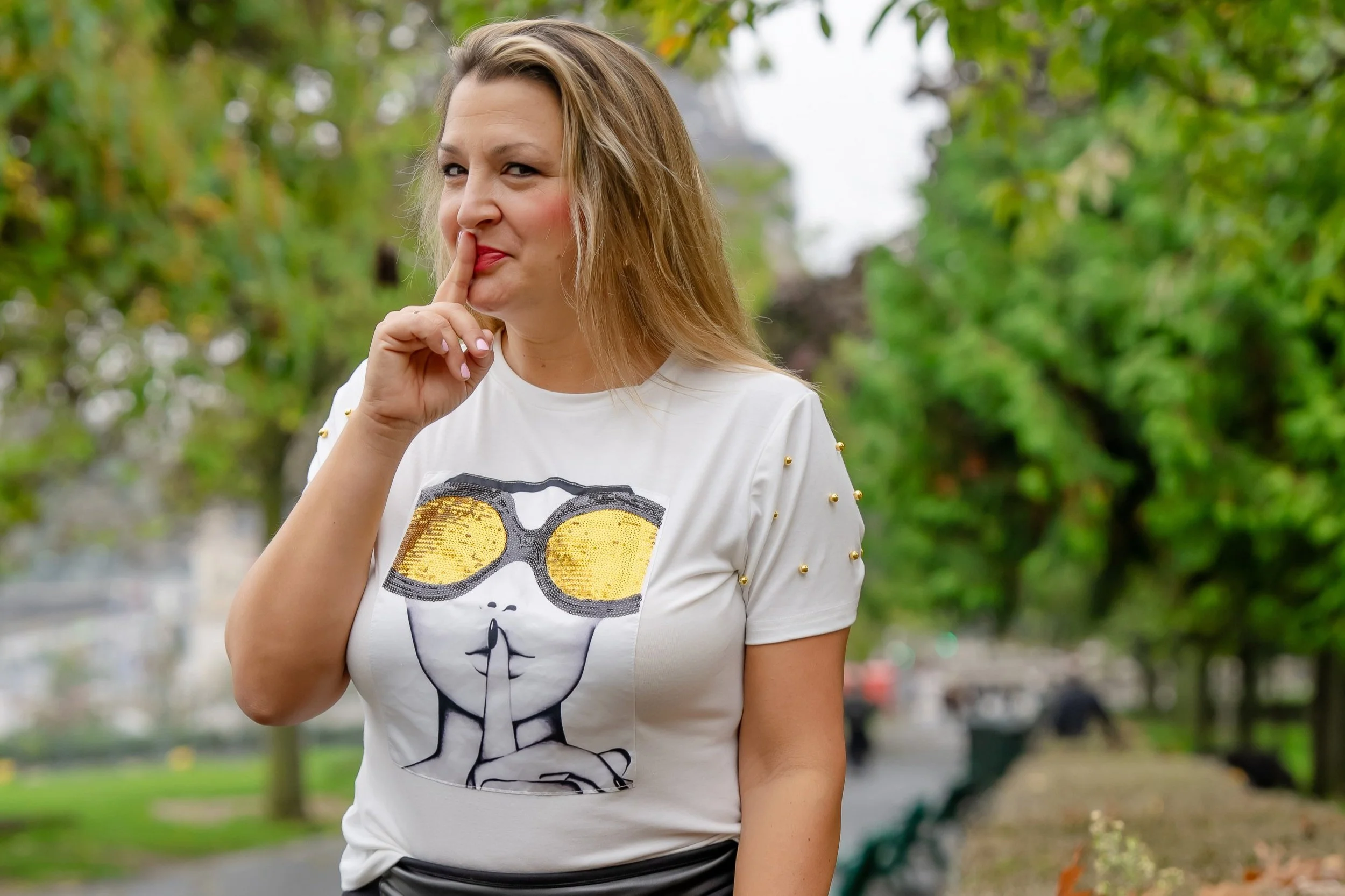 A casual outdoor lifestyle branding portrait of Caryn Grafton with finger to lips.