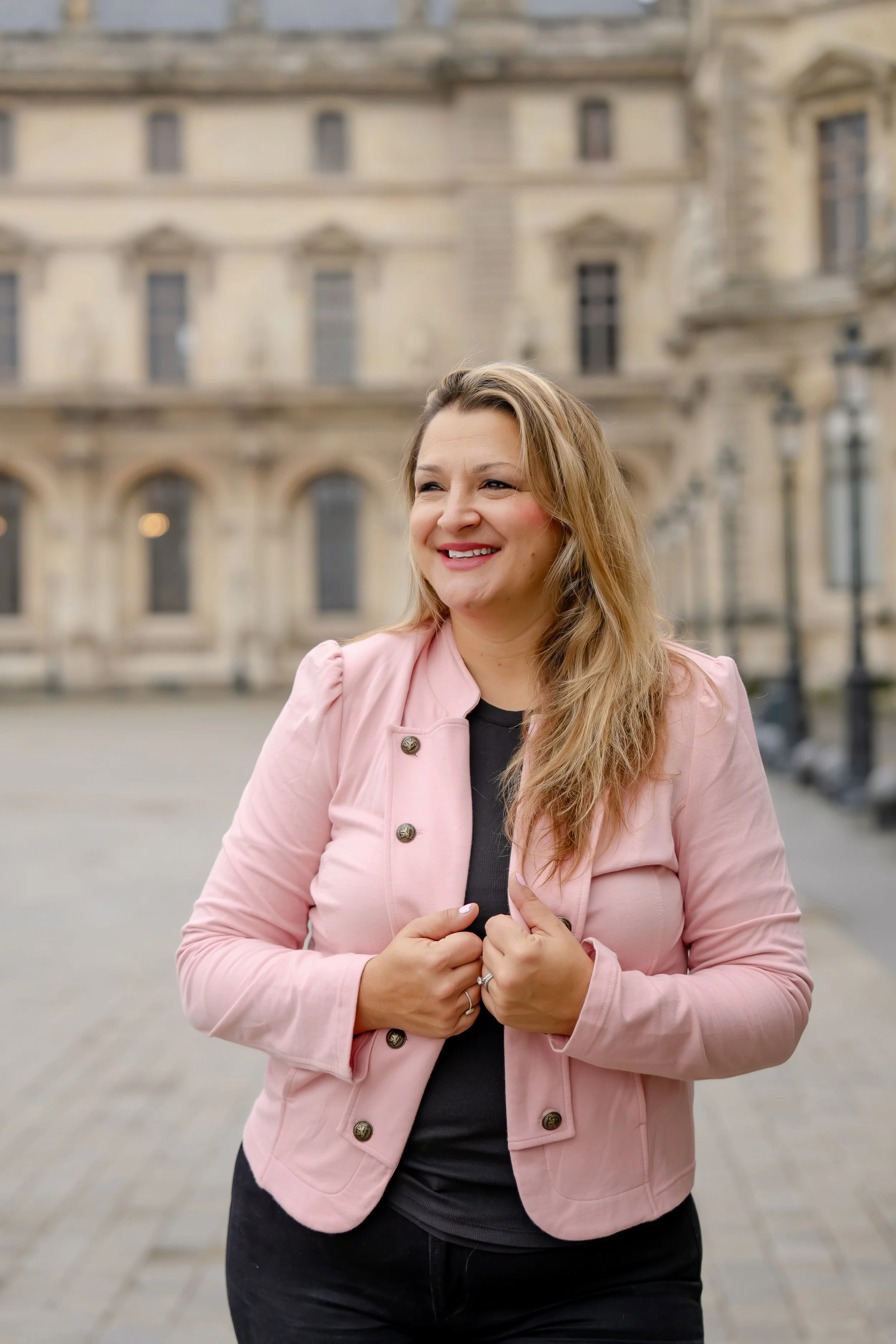 Full-length portrait of mortgage sales leader Caryn Grafton wearing a pink blazer and smiling in an outdoor park setting.