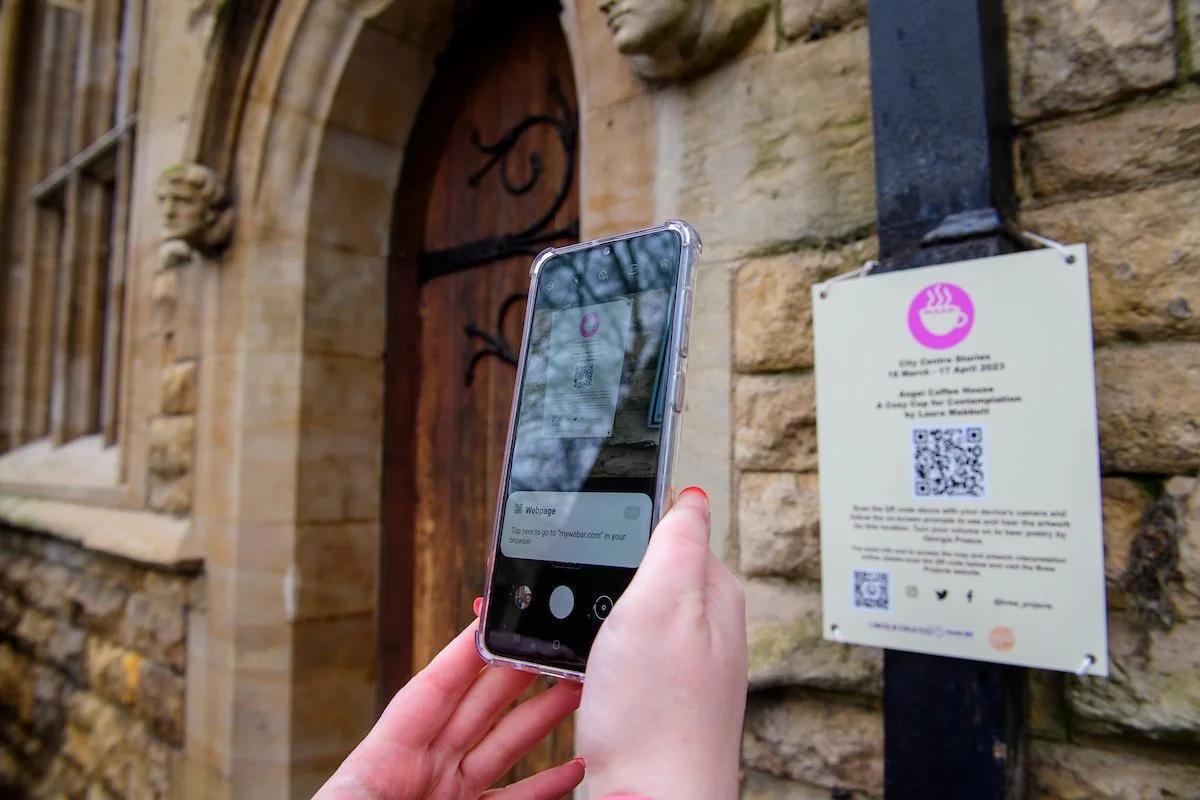 Photograph of person interacting with Brew Projects collaboration "City Centre Stories".