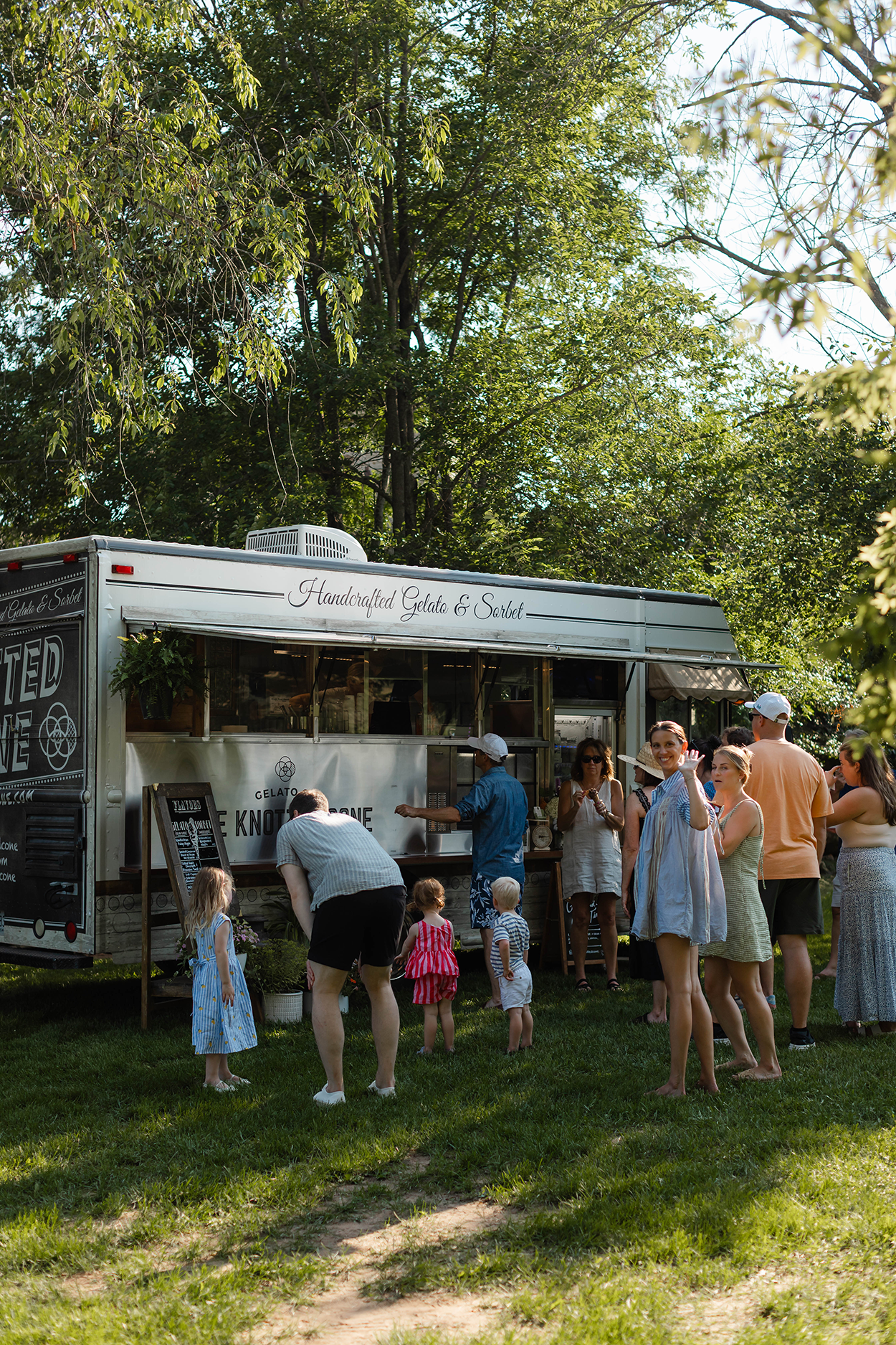 A gelato truck with a long cue of guests.