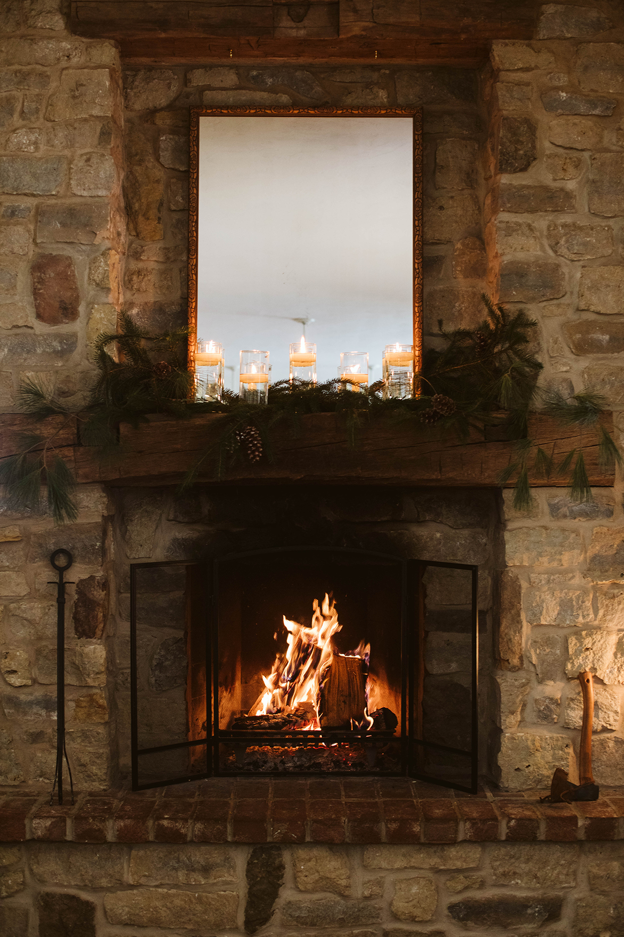 Stone fireplace with candle and winter decor