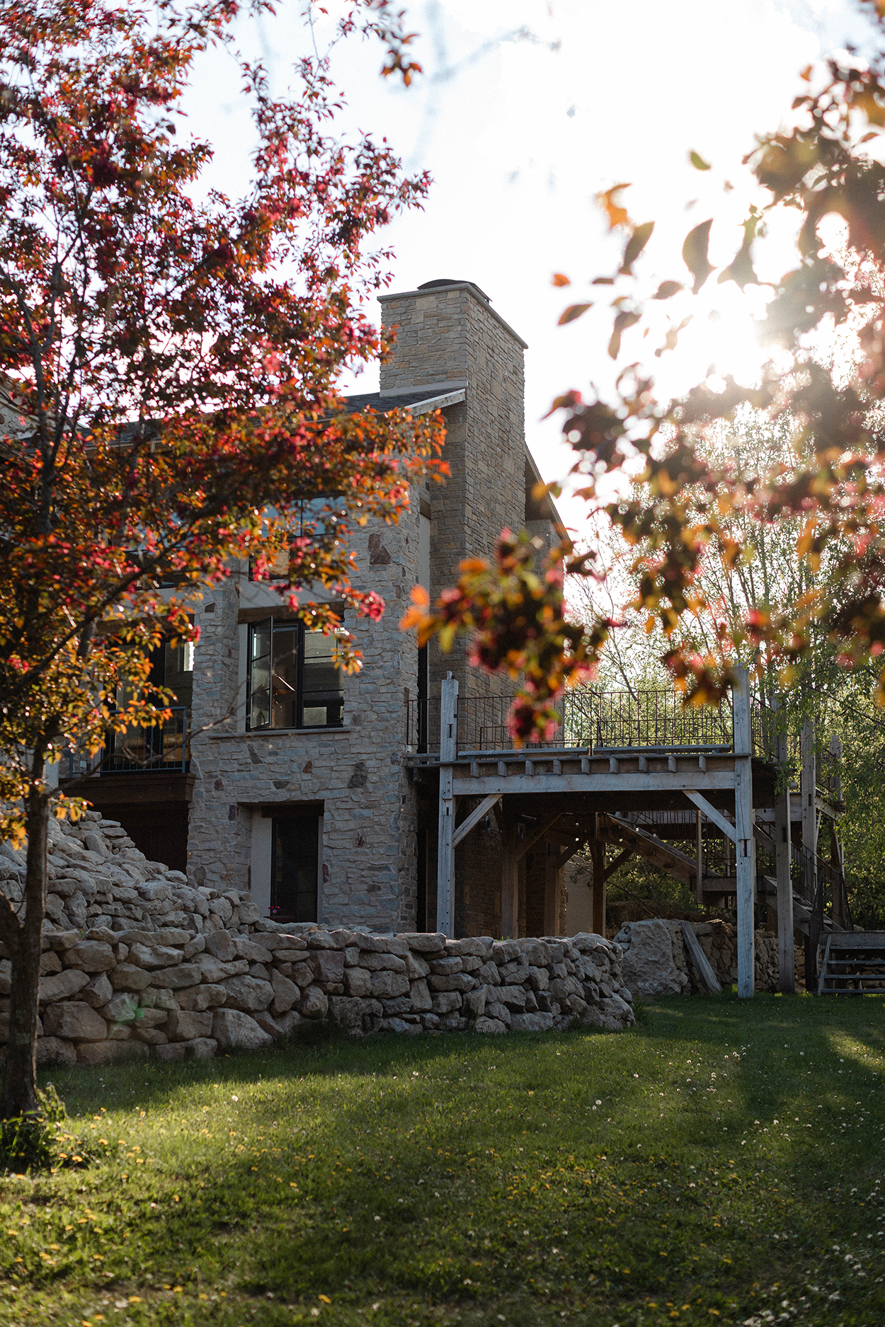 Villa hidden behind red plum trees with a sunset in the background.