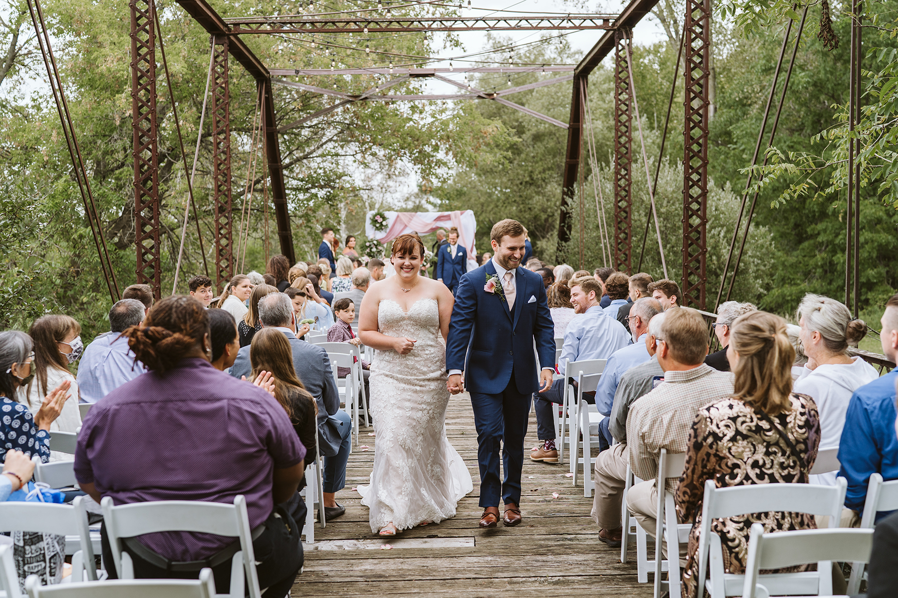 Couple walking down the wedding isle on a truss bridge