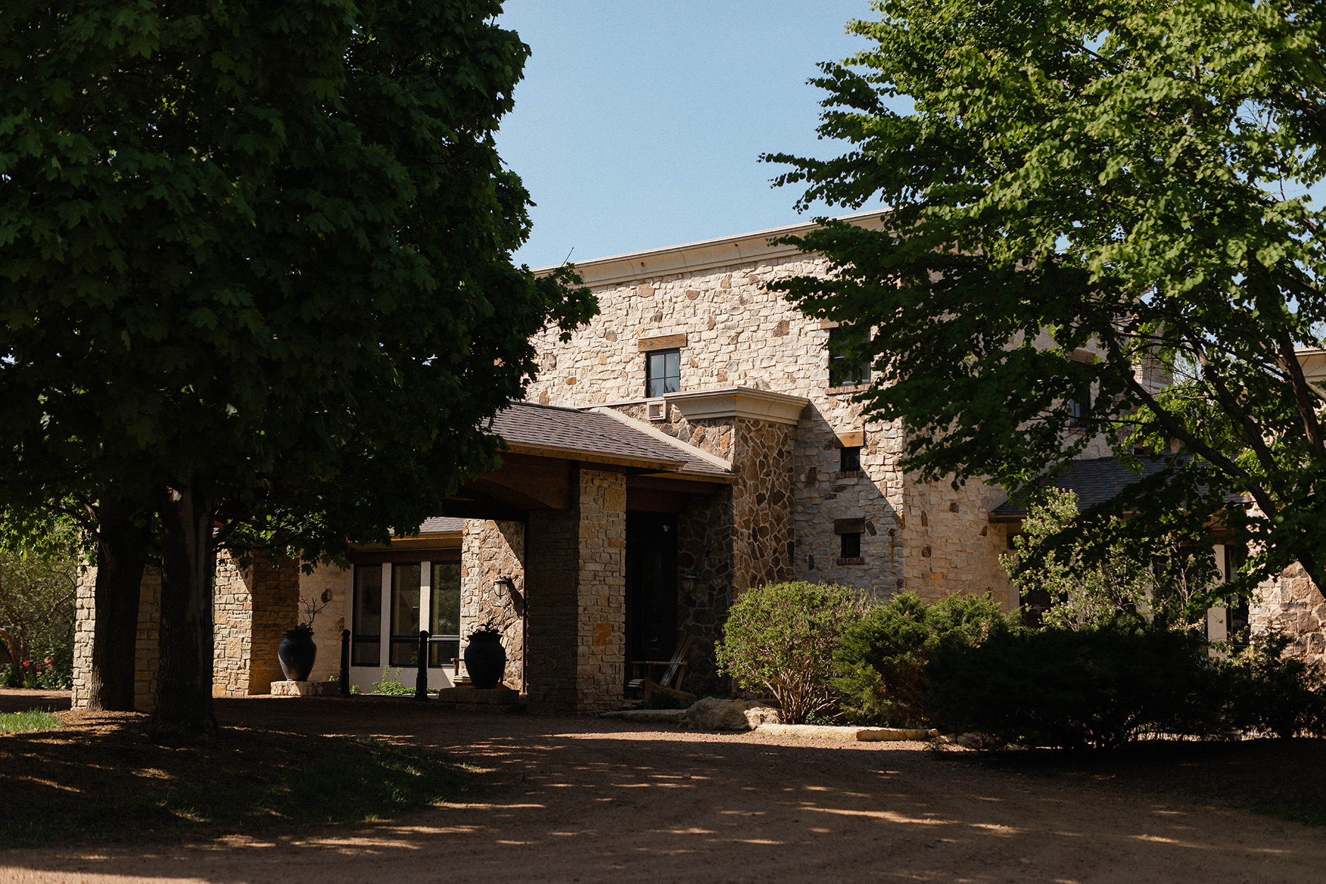 Stone villa at the end of a gravel drive.