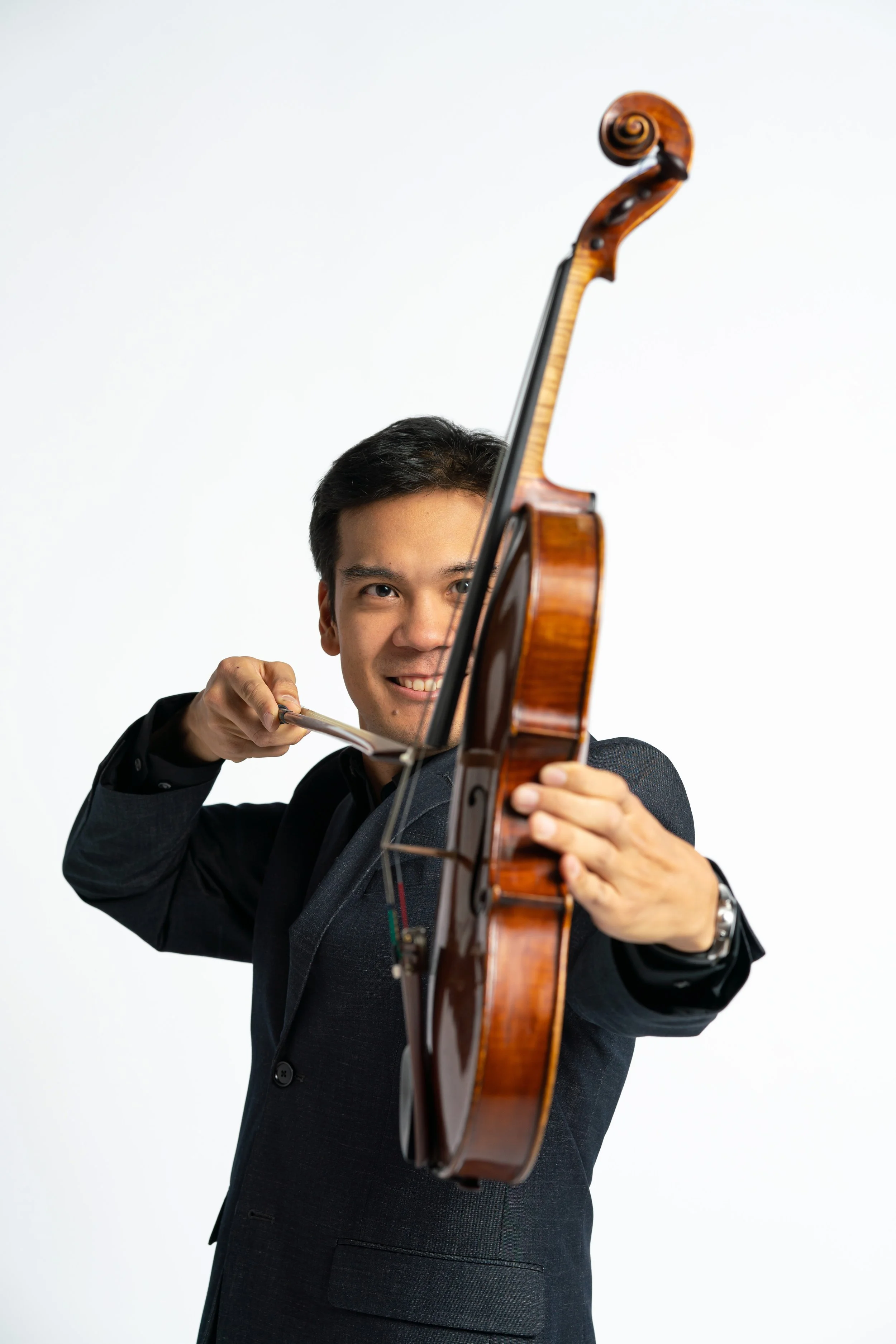 Young man holding a violin and bow like a bow and arrow.