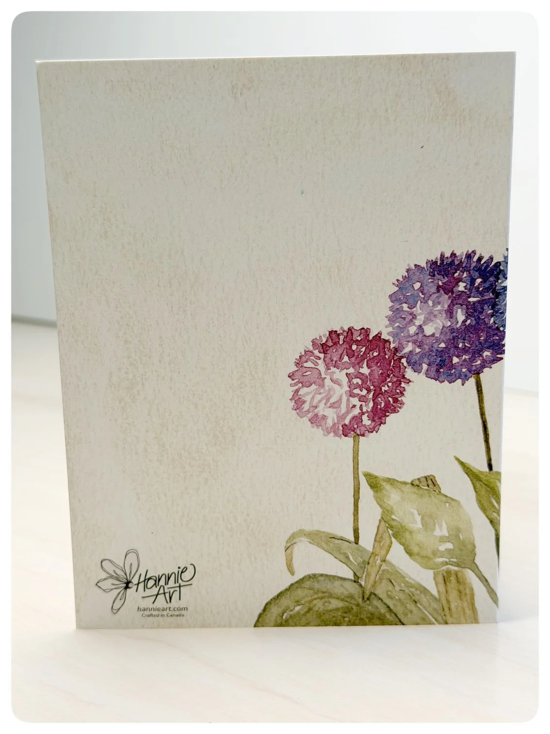 Back of floral birthday greeting card with watercolour alliums and Hannie Art logo