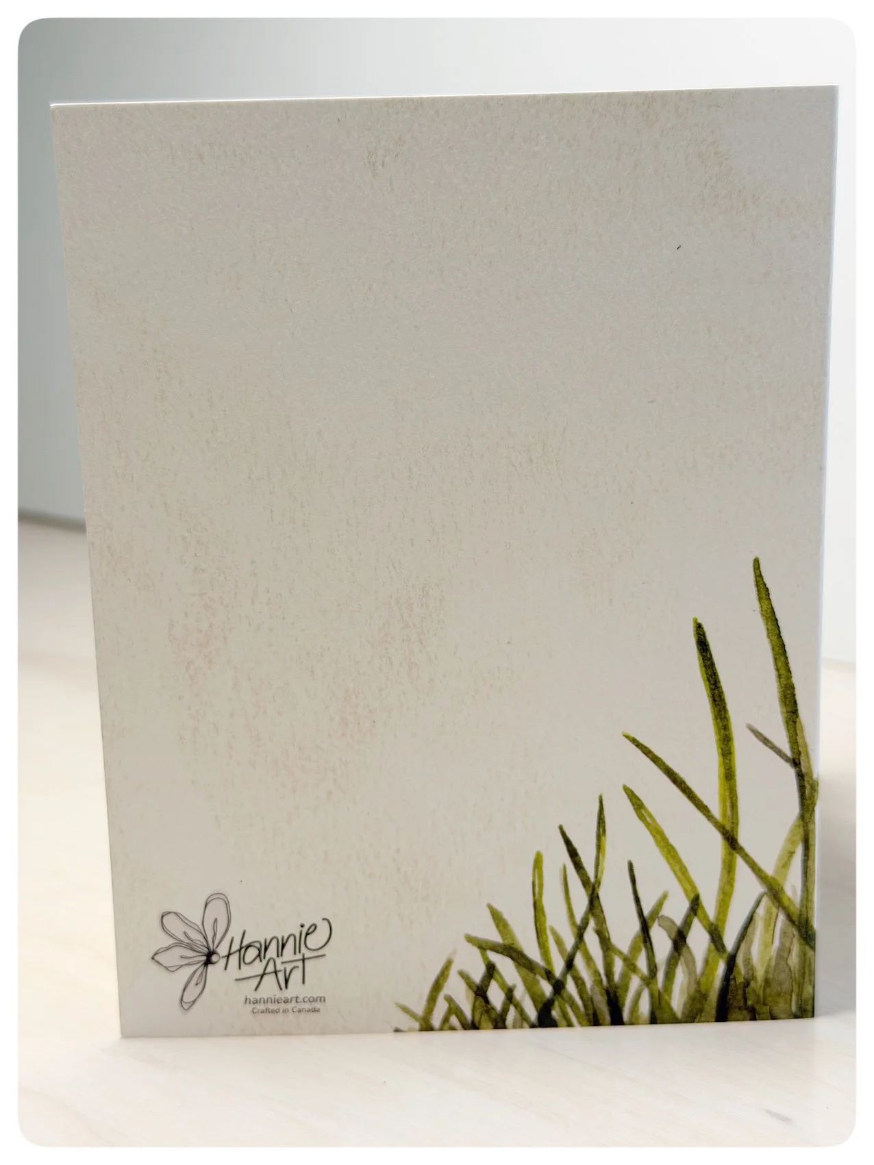 Back of dandelion sympathy greeting card with watercolour grasses and Hannie Art logo